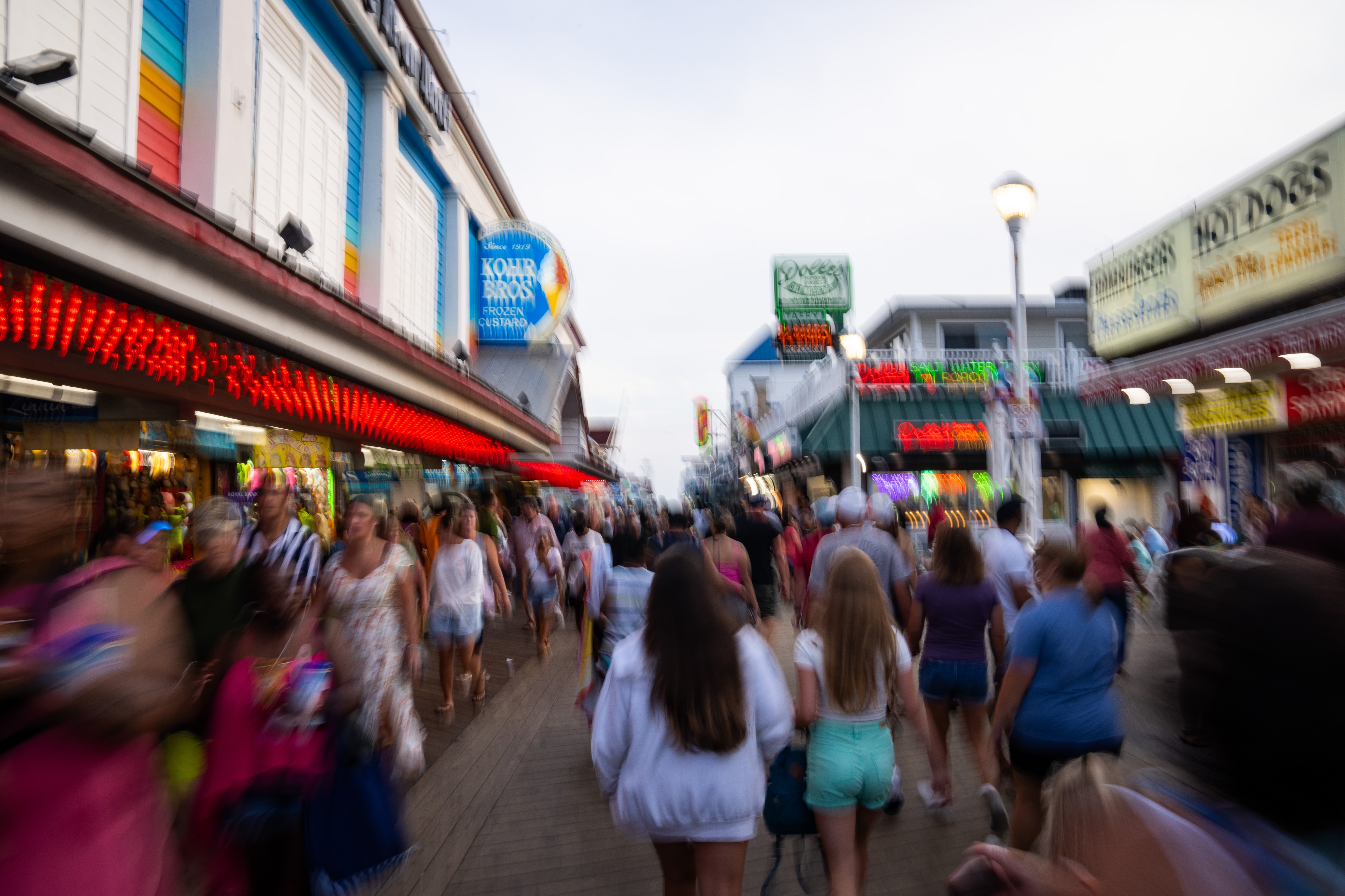 Slow shutter speed is used to capture people walking down the Ocean City Boardwalk.