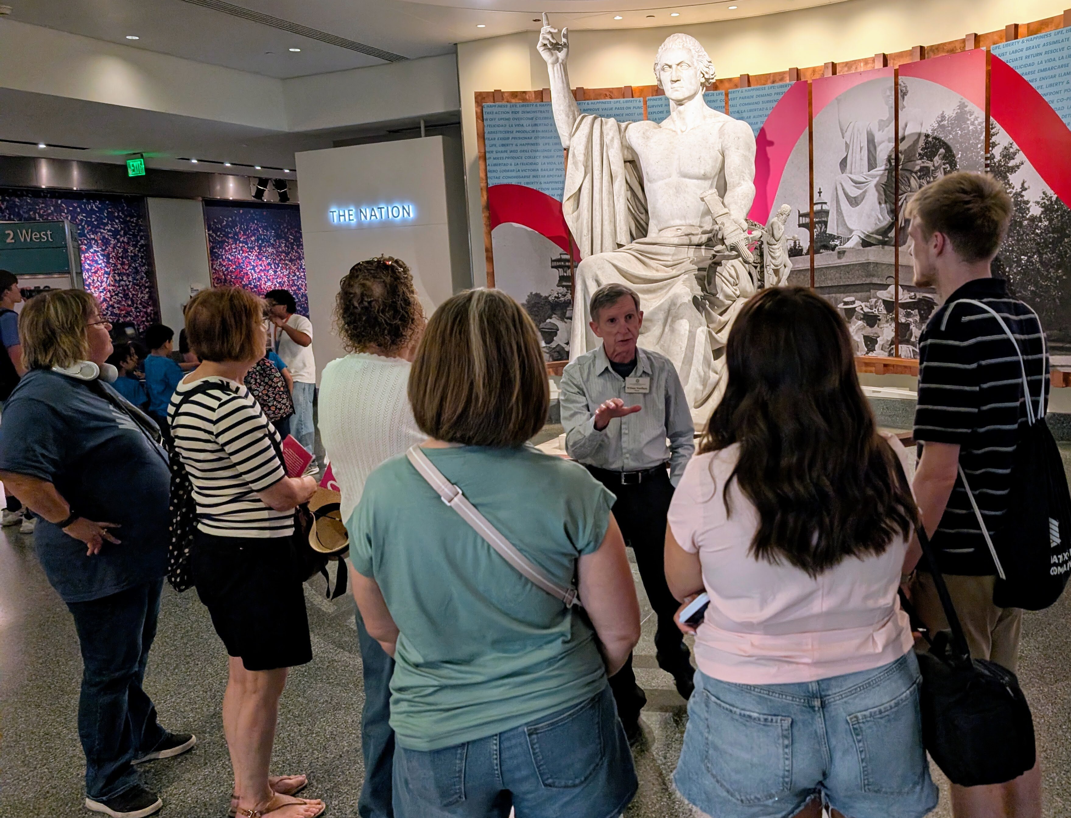 A docent explains why George Washington has no shirt in  Horatio Greenough's marble statue of the nation's founder at the National Museum of American History.