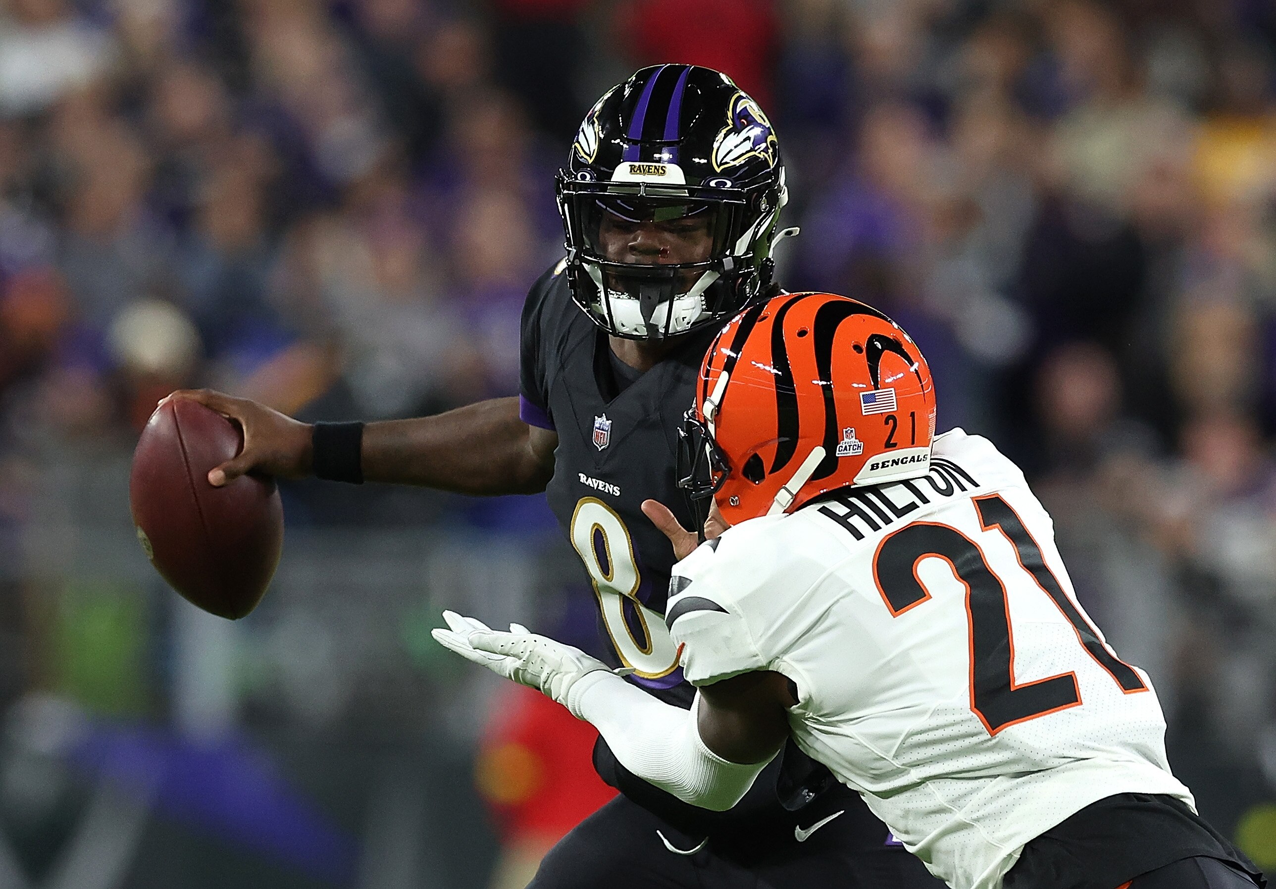Lamar Jackson #8 of the Baltimore Ravens looks to pass as he is pressured by Mike Hilton #21 of the Cincinnati Bengals in the first quarter at M&T Bank Stadium on October 09, 2022 in Baltimore, Maryland. (Photo by Todd Olszewski/Getty Images)