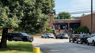 Baltimore Police vehicles are parked outside The Commodore John Rodgers School, which is temporarily holding classes in Dundalk, after a report that ICE (Immigration and Customs Enforcement) officers arrested a person during school drop-offs on Thursday morning.