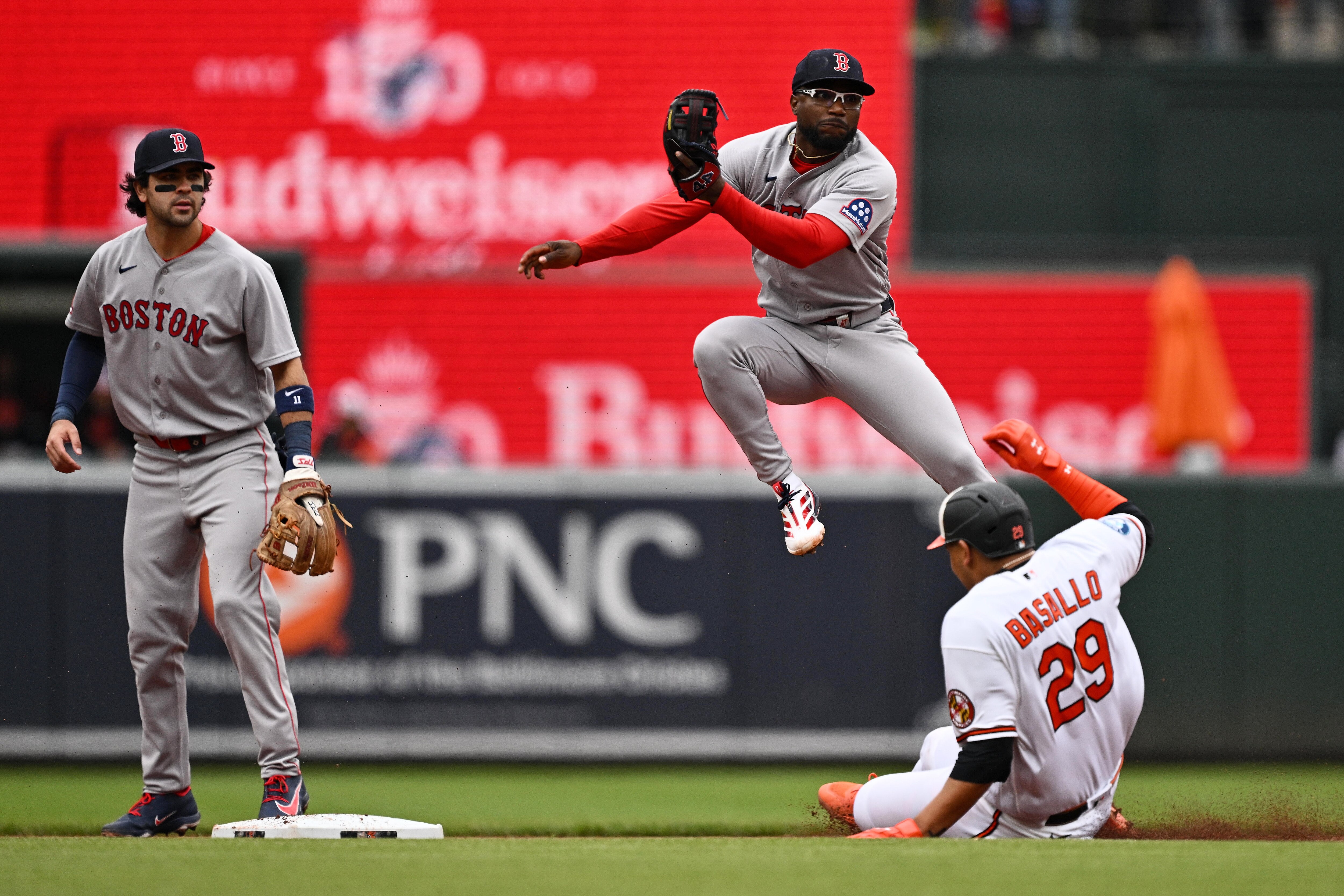Andruw Monasterio of the Red Sox throws to first base  to complete a double play after forcing out Samuel Basallo of the Orioles.