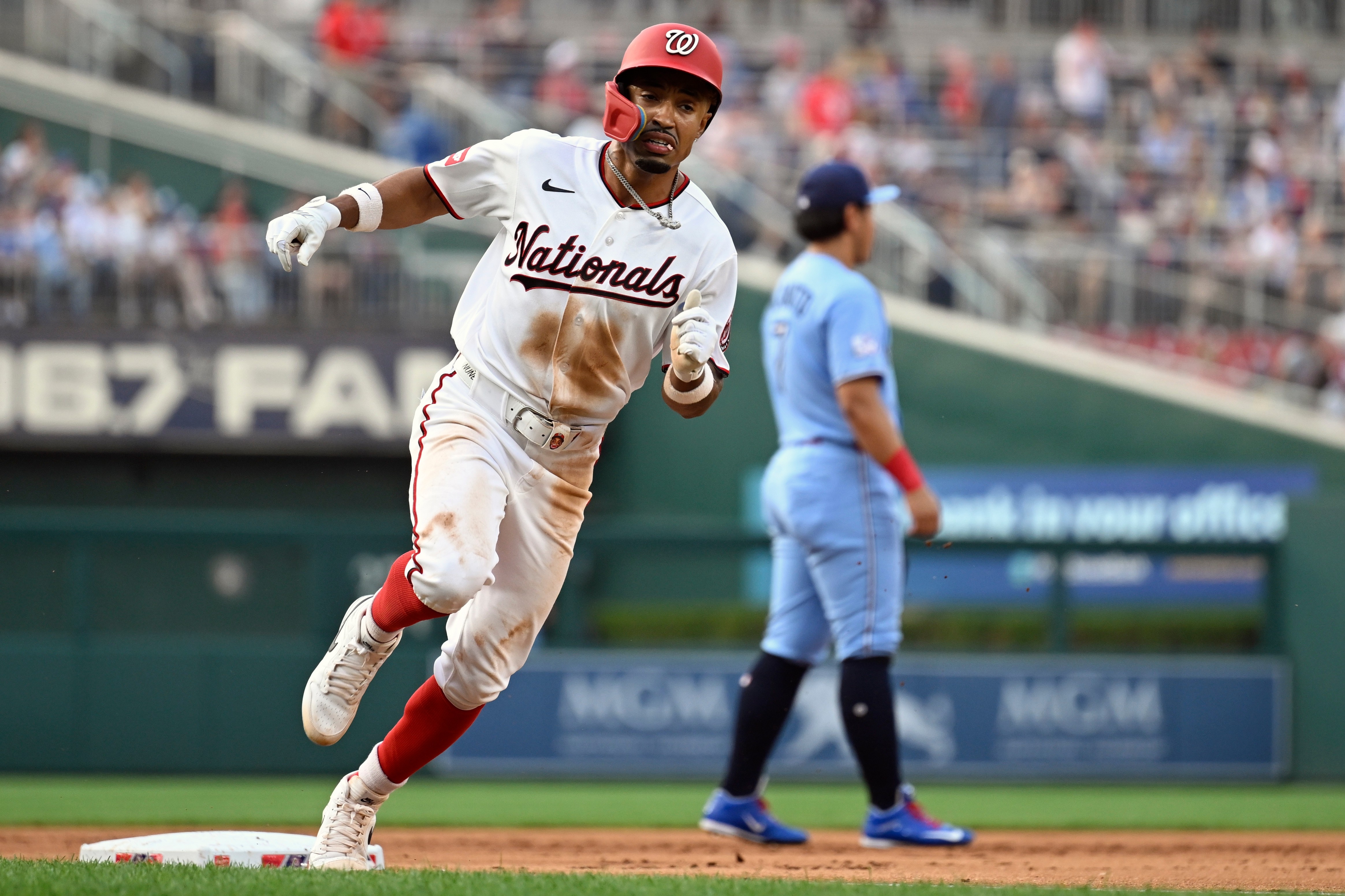 Washington Nationals' Nasim Nuñez, left, heads home to score on an RBI double by Luis García Jr. during the second inning.