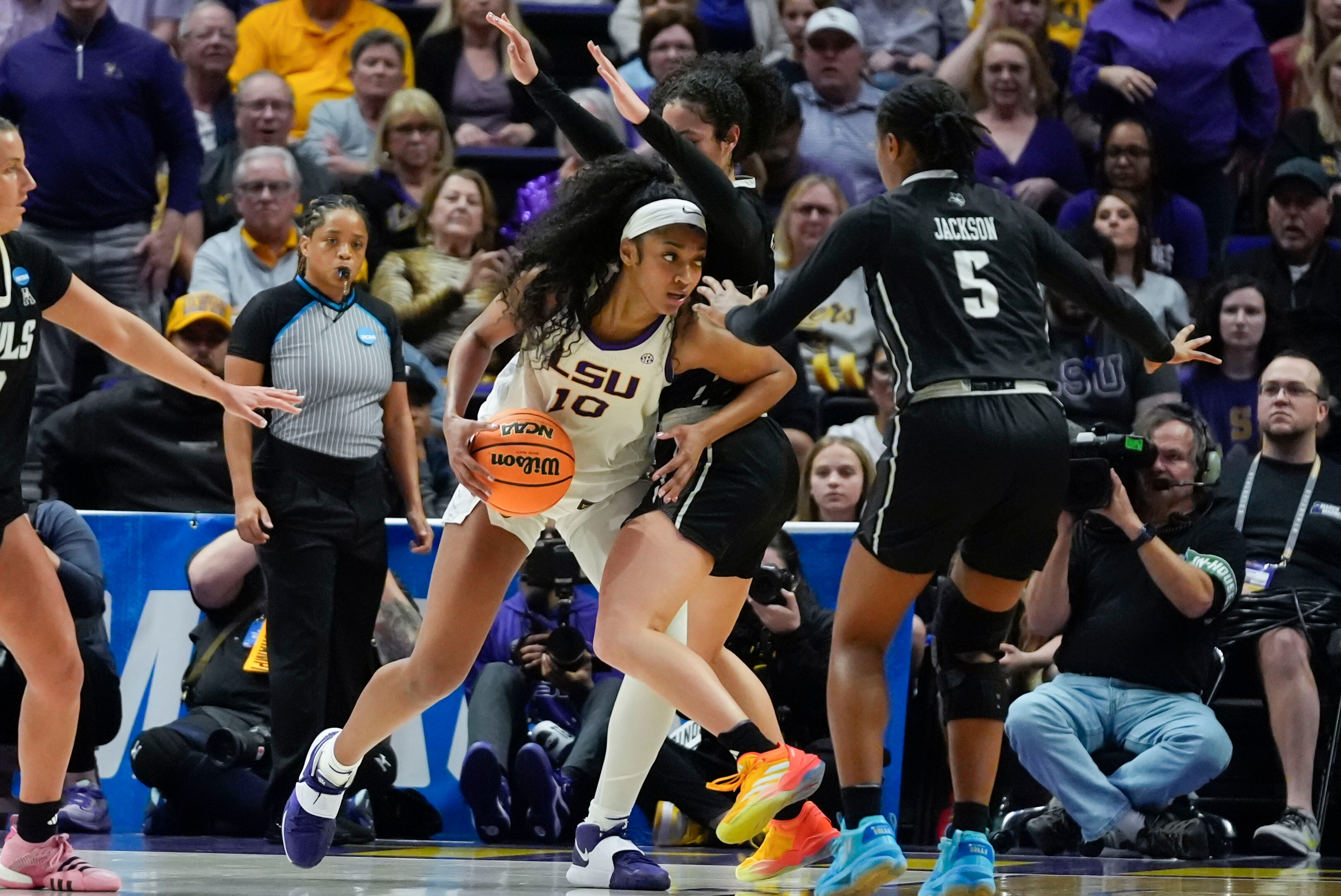 LSU forward Angel Reese drives to the basket against Rice forward Malia Fisher and guard Destiny Jackson in an NCAA first-round game Friday.