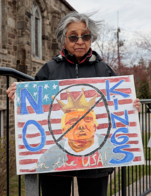 Hansa Shah, 82, holds a sign during a protest.