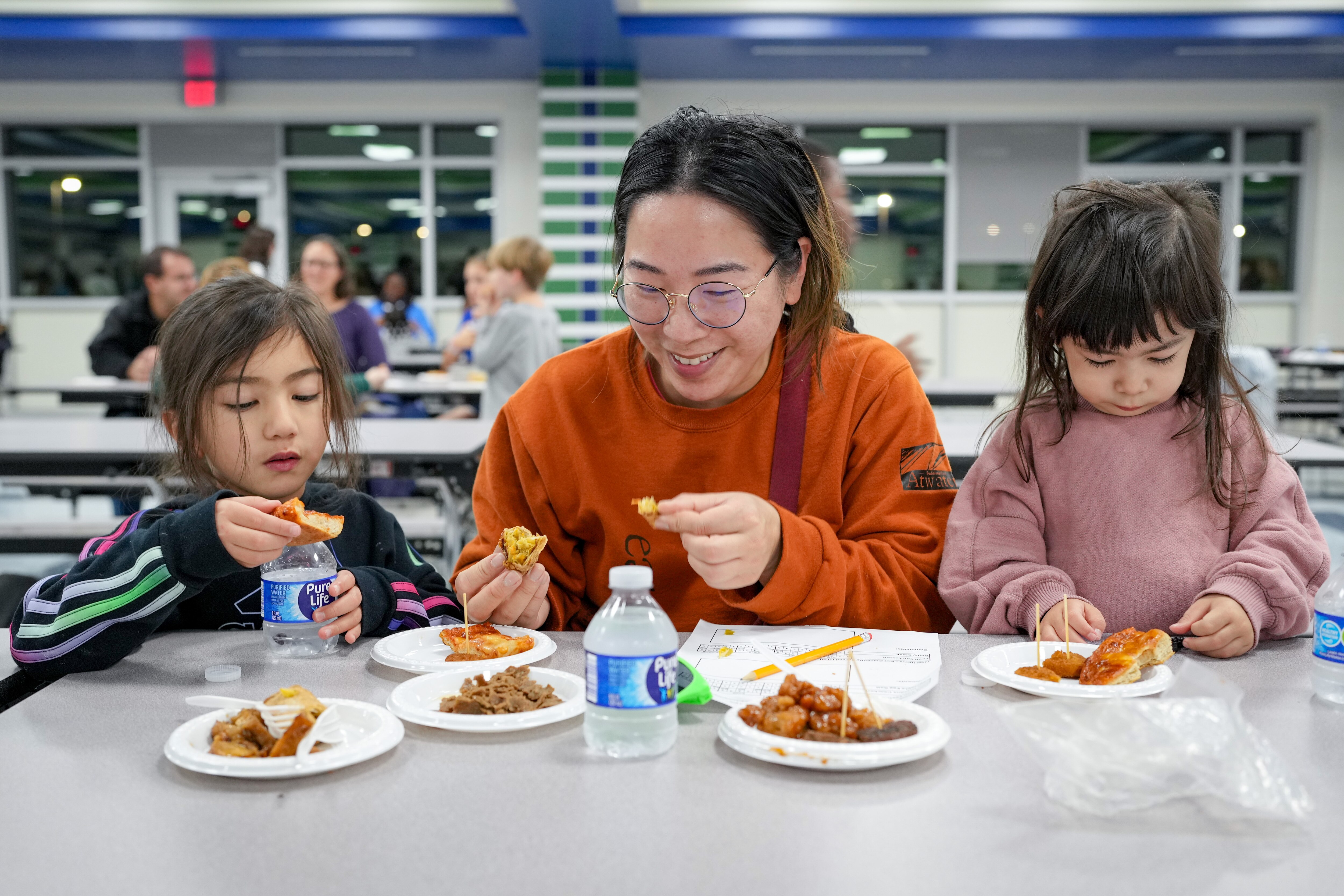Jean Diep, center, tries different dishes with her daughters Sophia, 6, and Frankie, 3, during a taste test of the Howard County Public School System’s school lunch menu at the Guilford Park High School cafeteria