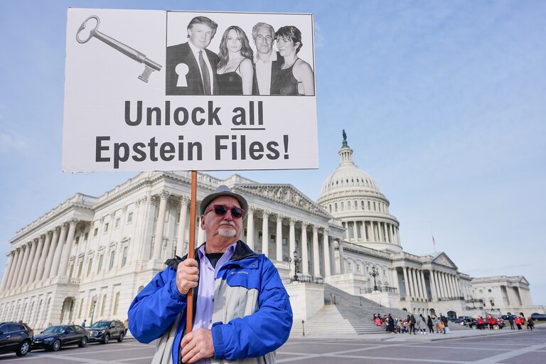 Gary Rush, College Park, MD, holds a sign before a news conference on the Epstein files in front of the Capitol, Tuesday, Nov. 18, 2025, in Washington. (AP Photo/Mariam Zuhaib)