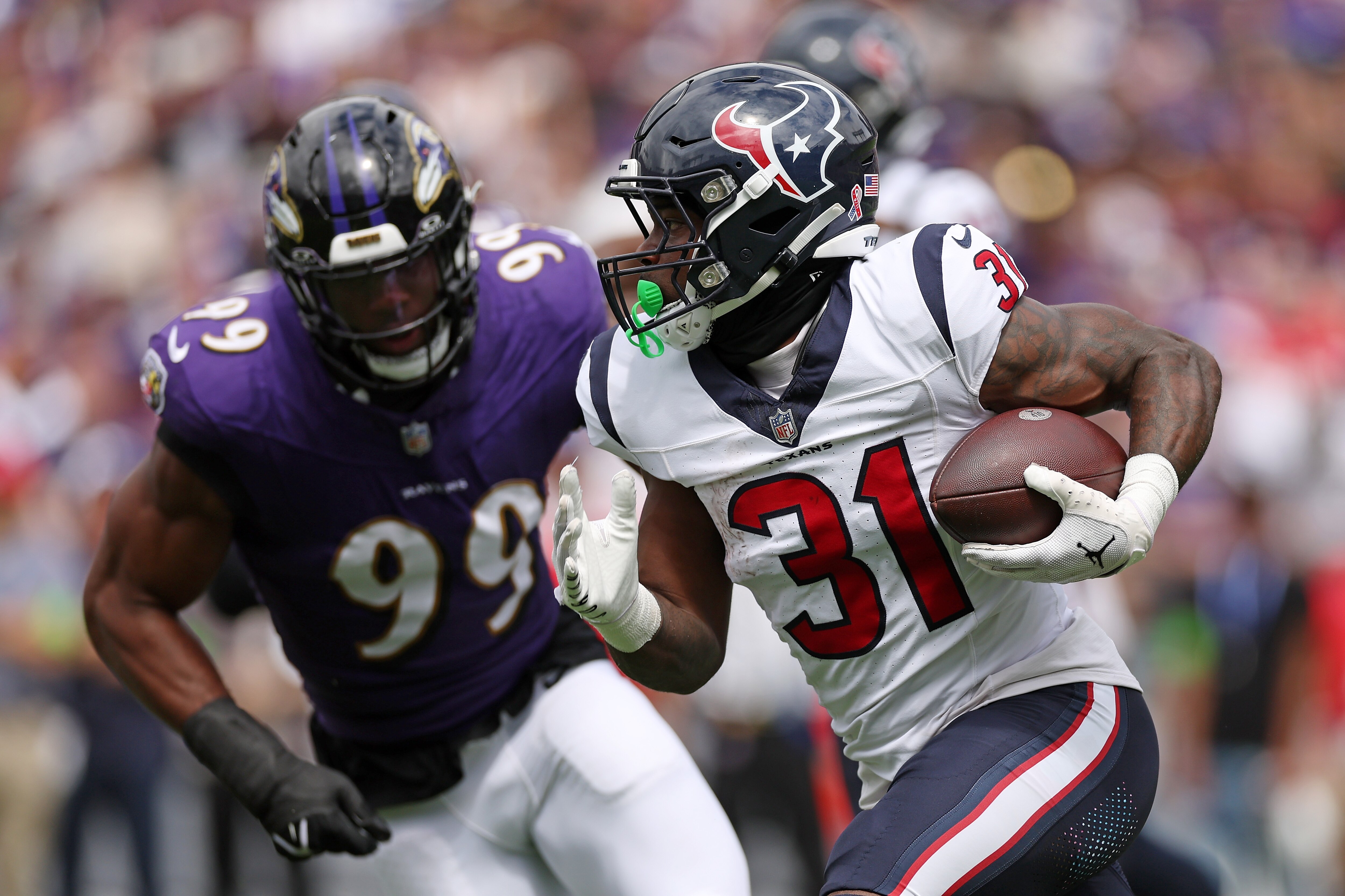 Dameon Pierce, #31 of the Houston Texans, carries the ball against Odafe Oweh, #99 of the Baltimore Ravens, at M&T Bank Stadium on Sept. 10, 2023 in Baltimore, Maryland.