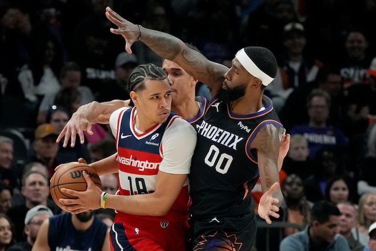 Phoenix Suns forwards Royce O'Neale (00) and Oso Ighodaro defend against Washington Wizards forward Kyshawn George (18) during the first half of an NBA basketball game, Sunday, Jan. 11, 2026, in Phoenix.