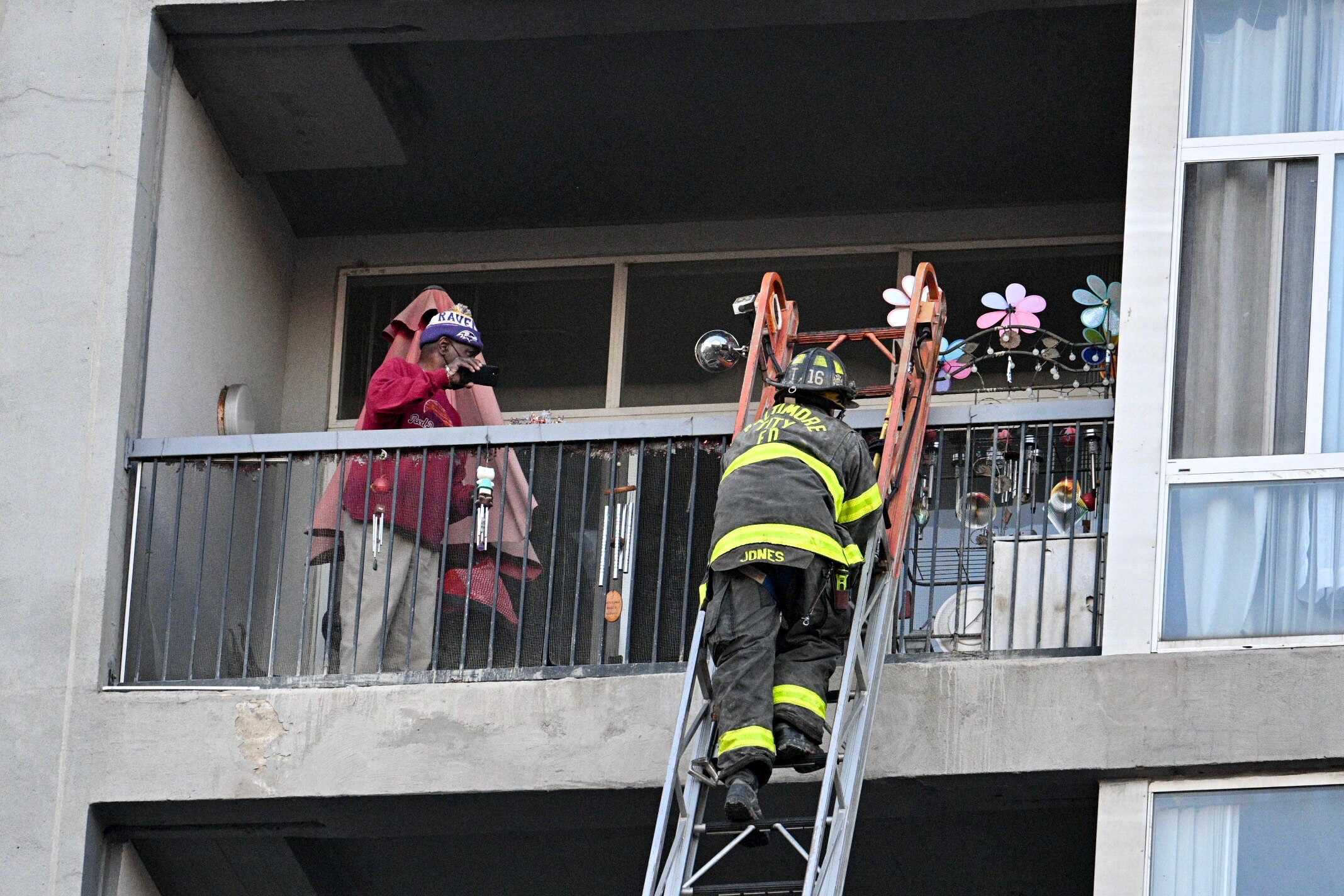 Baltimore City firefighters help evacuate residents from the 222 Saratoga apartment building in downtown on Thursday.
