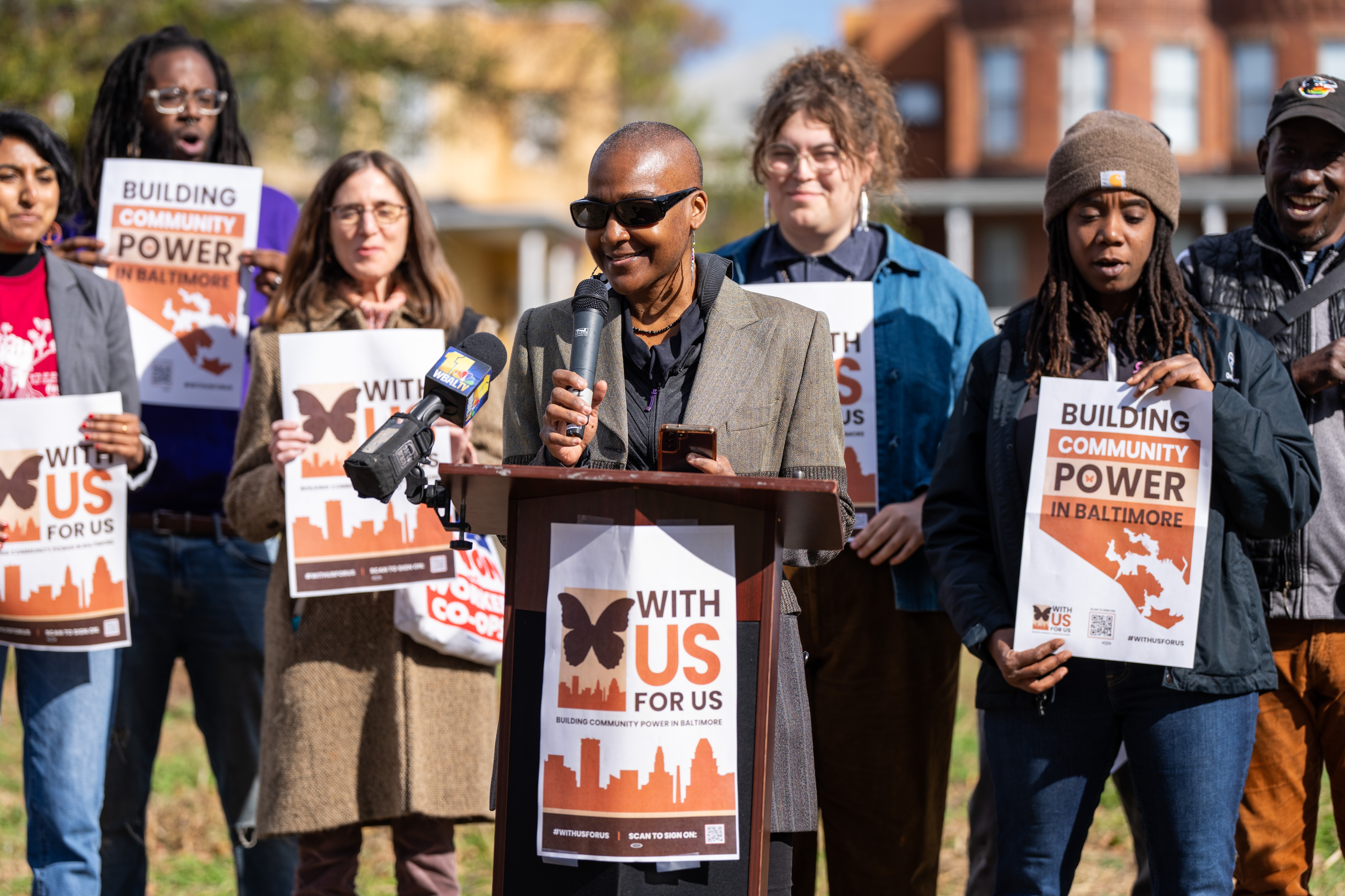 Tisha Guthrie emcees the kickoff event for With Us for Us, a coalition centered around community wealth building in Baltimore City, at Plantation Park Heights Urban Garden on Wednesday, Nov. 8, 2023.