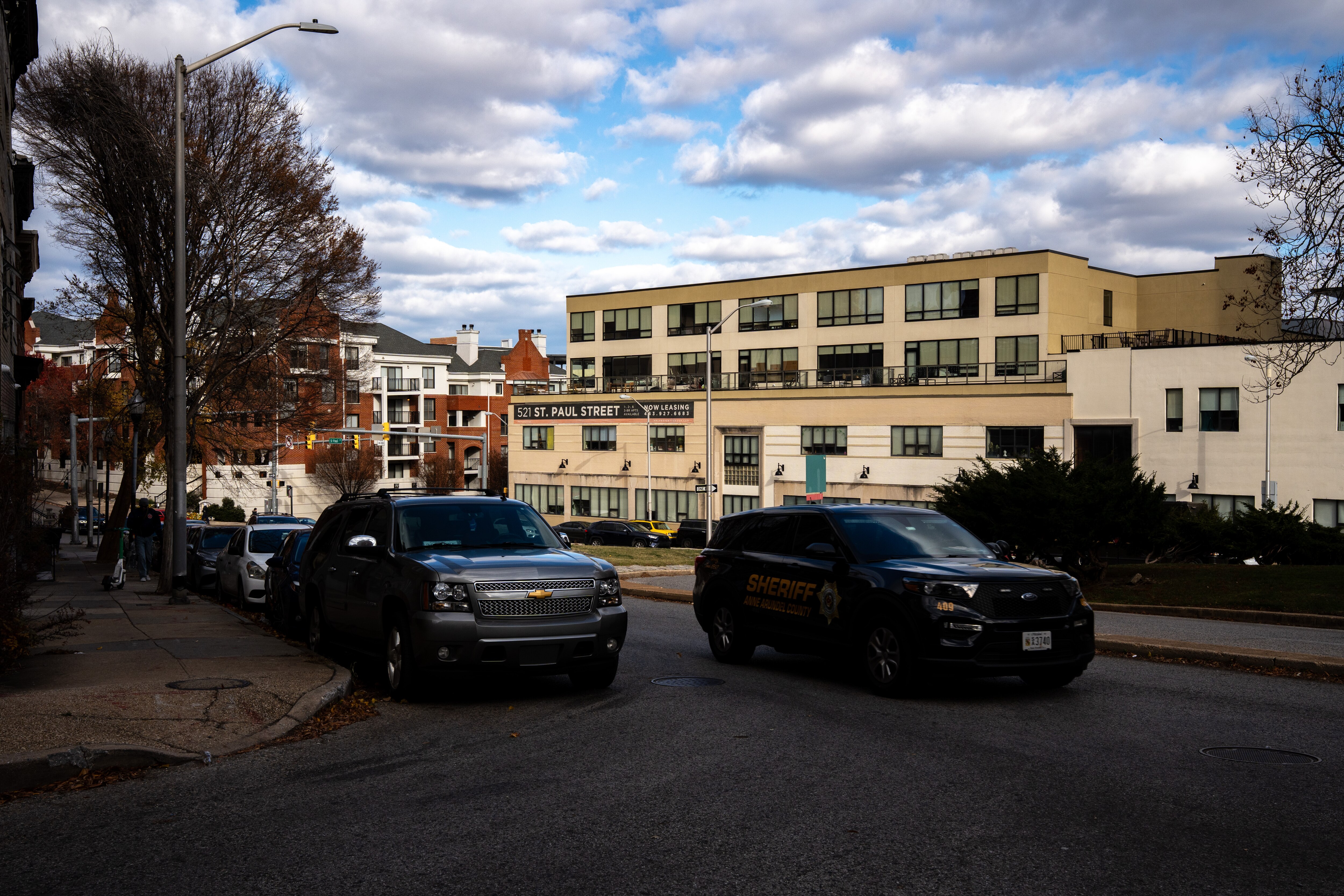 A police car drives past the 500 block of St. Paul St. on Friday, Nov. 28, 2025, where a 49-year-old woman from Northeast Baltimore was arrested last month and charged with fatally beating a city traffic worker during an argument over a parking spot.
