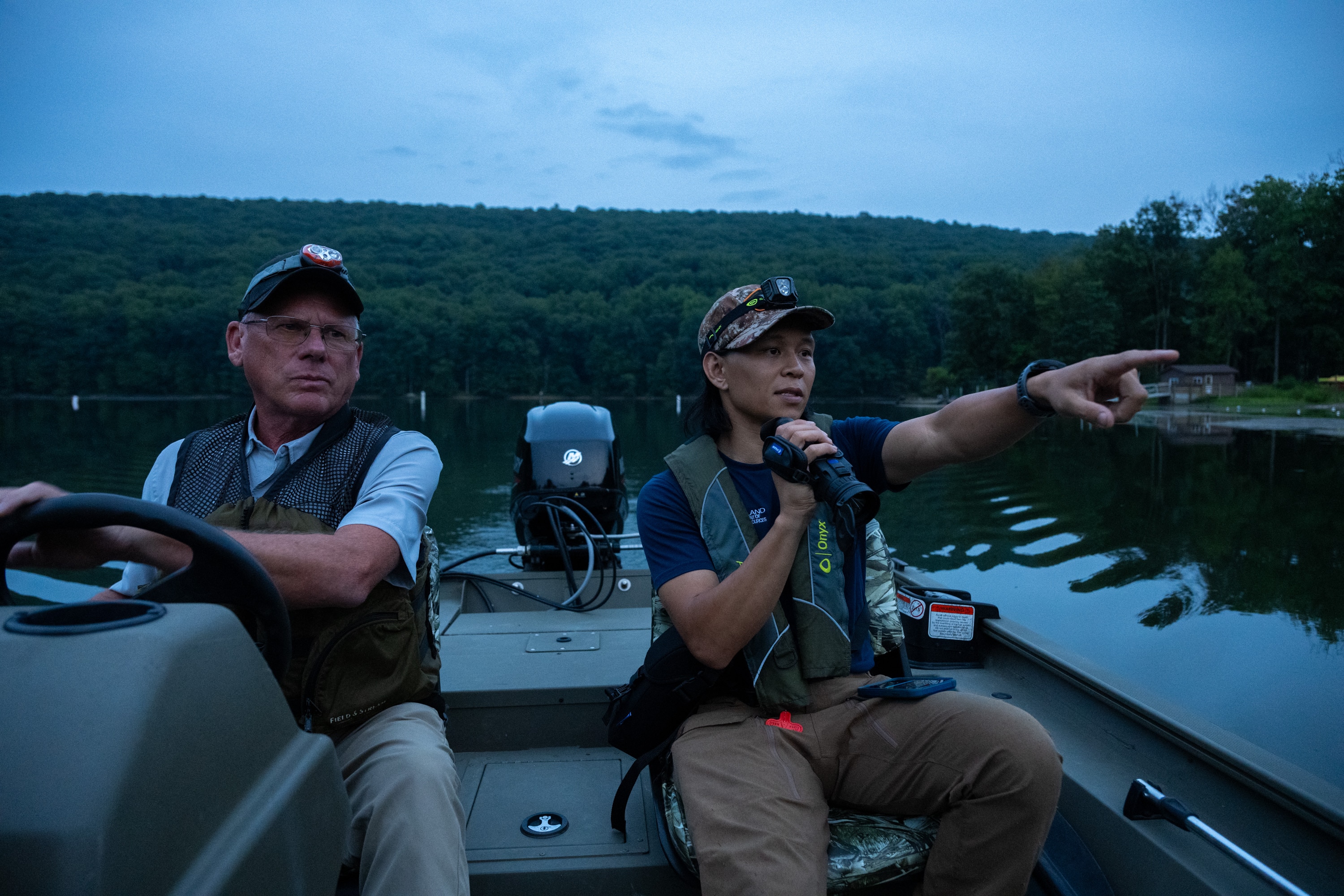 Joshua Tabora, a wildlife biologist with the Maryland Department of Natural Resources, points out a great blue heron that appeared in his thermal monocular while searching for beavers on Hunting Creek Lake at Cunningham Falls State Park.