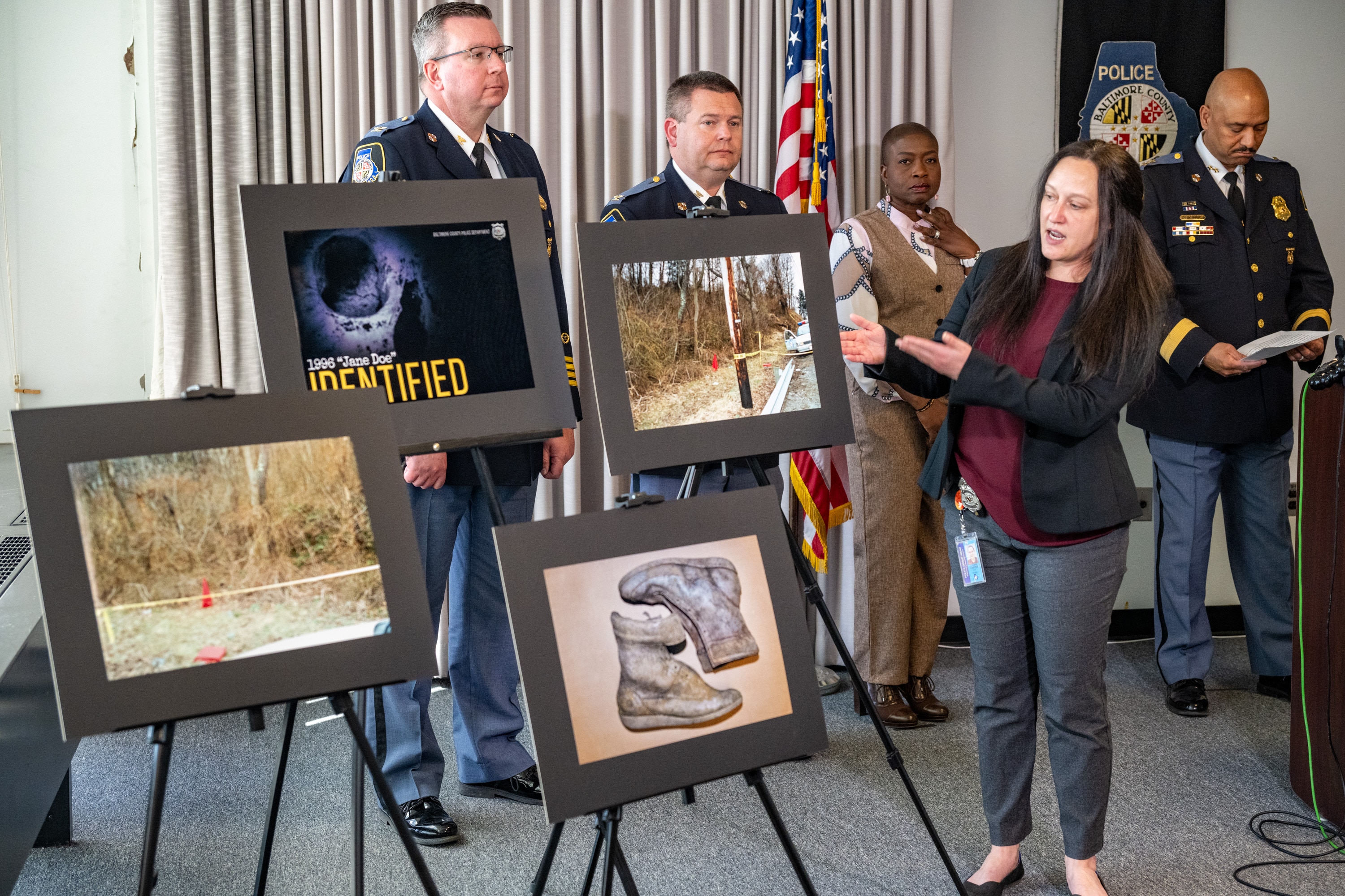 Cpl. Dona Carter of Baltimore County’s cold case and missing persons squad shows photos taken in 1996 along Falls Road when the body of a woman identified on Thursday as Leoria Smith was found.