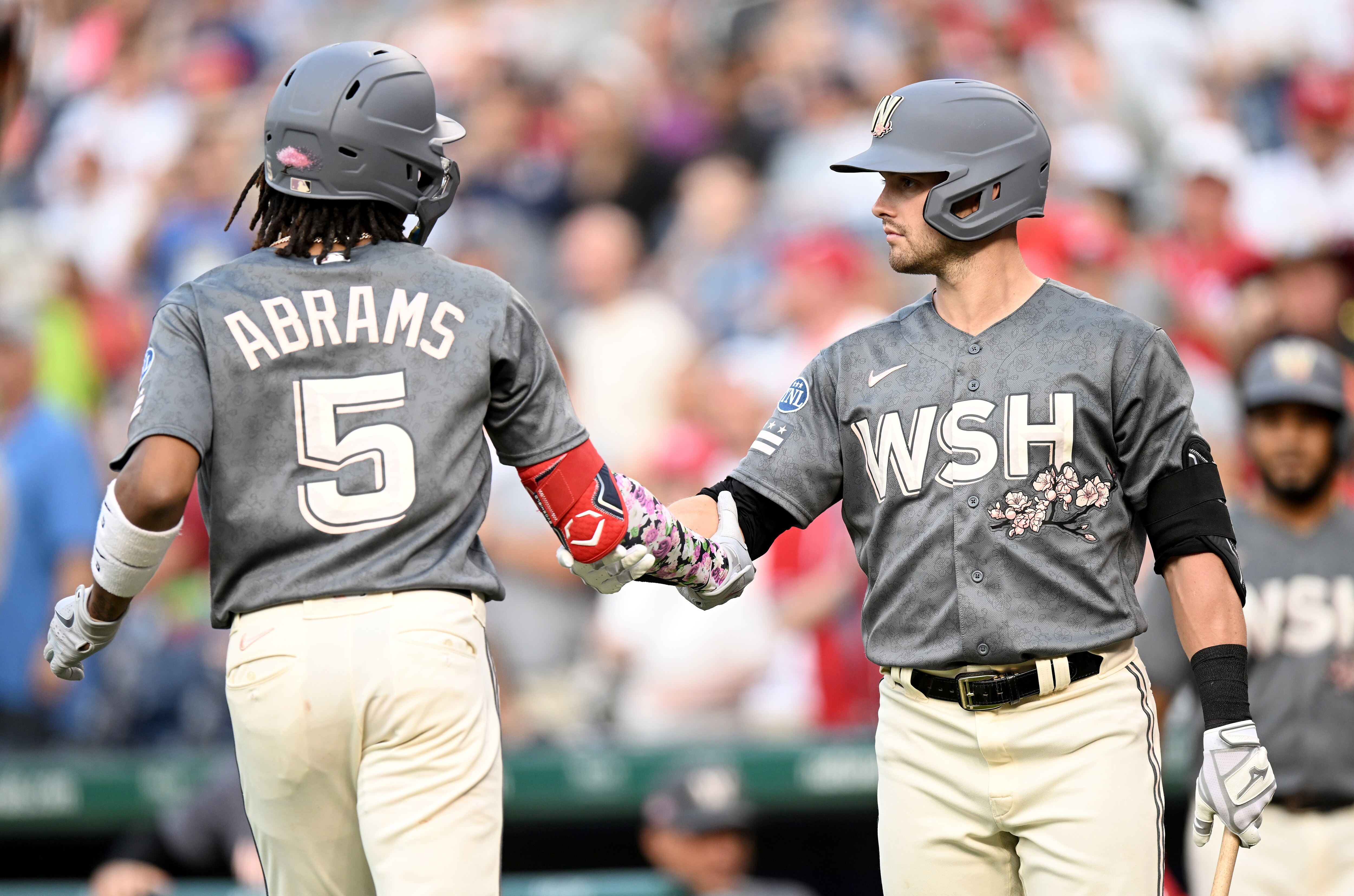 CJ Abrams shakes hands with Lane Thomas after hitting a home run. Both players homered in the Nationals' 5-3 win over the Giants.