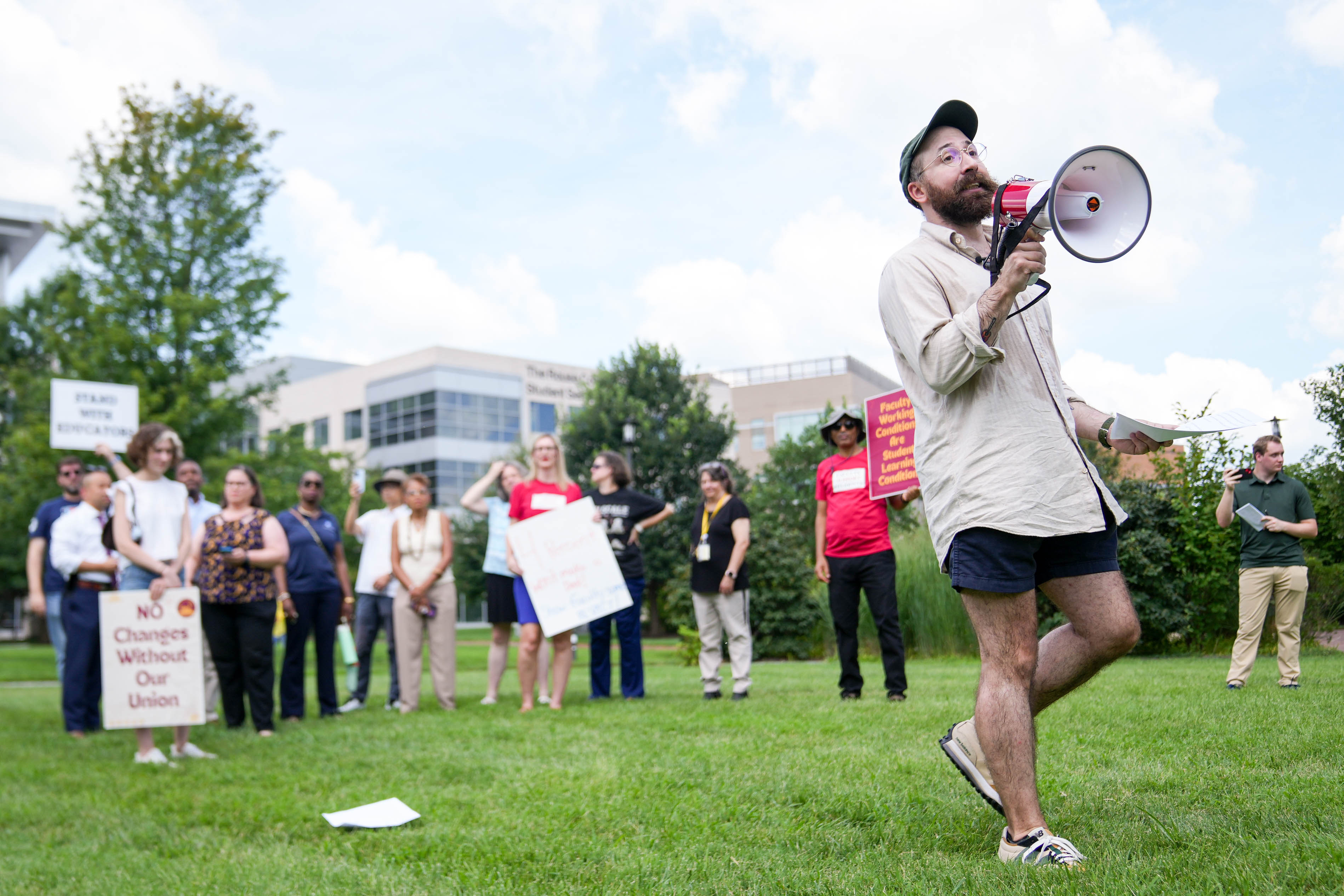 HCC faculty member Tim Bruno uses a megaphone to deliver remarks during a rally to support Howard Community College faculty on the school’s quad in Columbia on Monday.