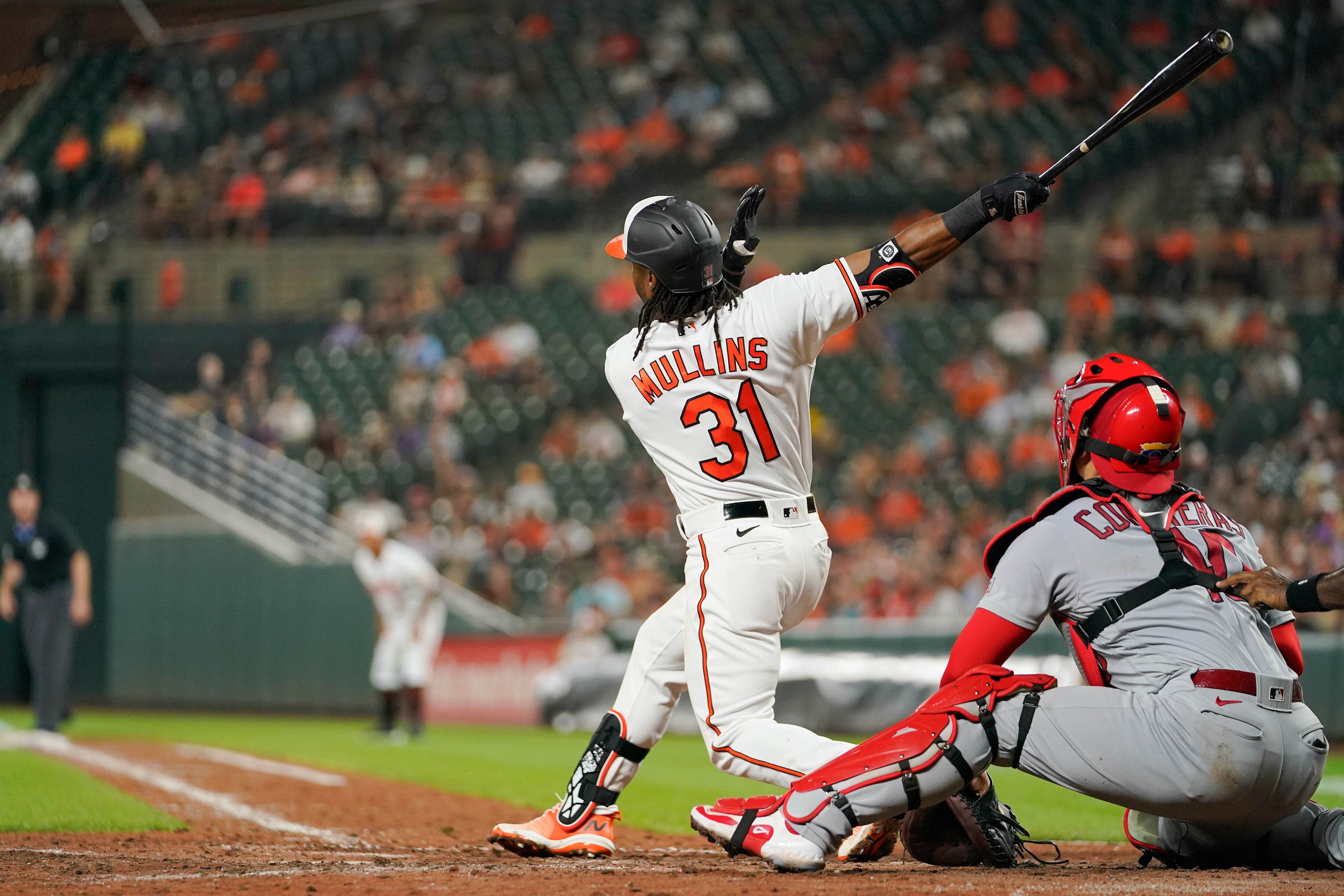 Baltimore Orioles' Cedric Mullins follows through on a swing as he and St. Louis Cardinals catcher Willson Contreras watch the ball on a grand slam off relief pitcher Andre Pallante in the fifth inning of a baseball game, Monday, Sept. 11, 2023 in Baltimore.
