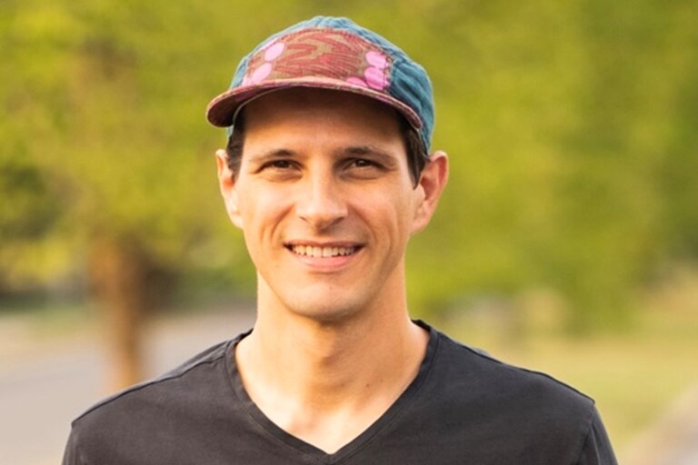 Headshot of City Councilman Ryan Dorsey smiling, wearing a black shirt and multicolored ballcap.