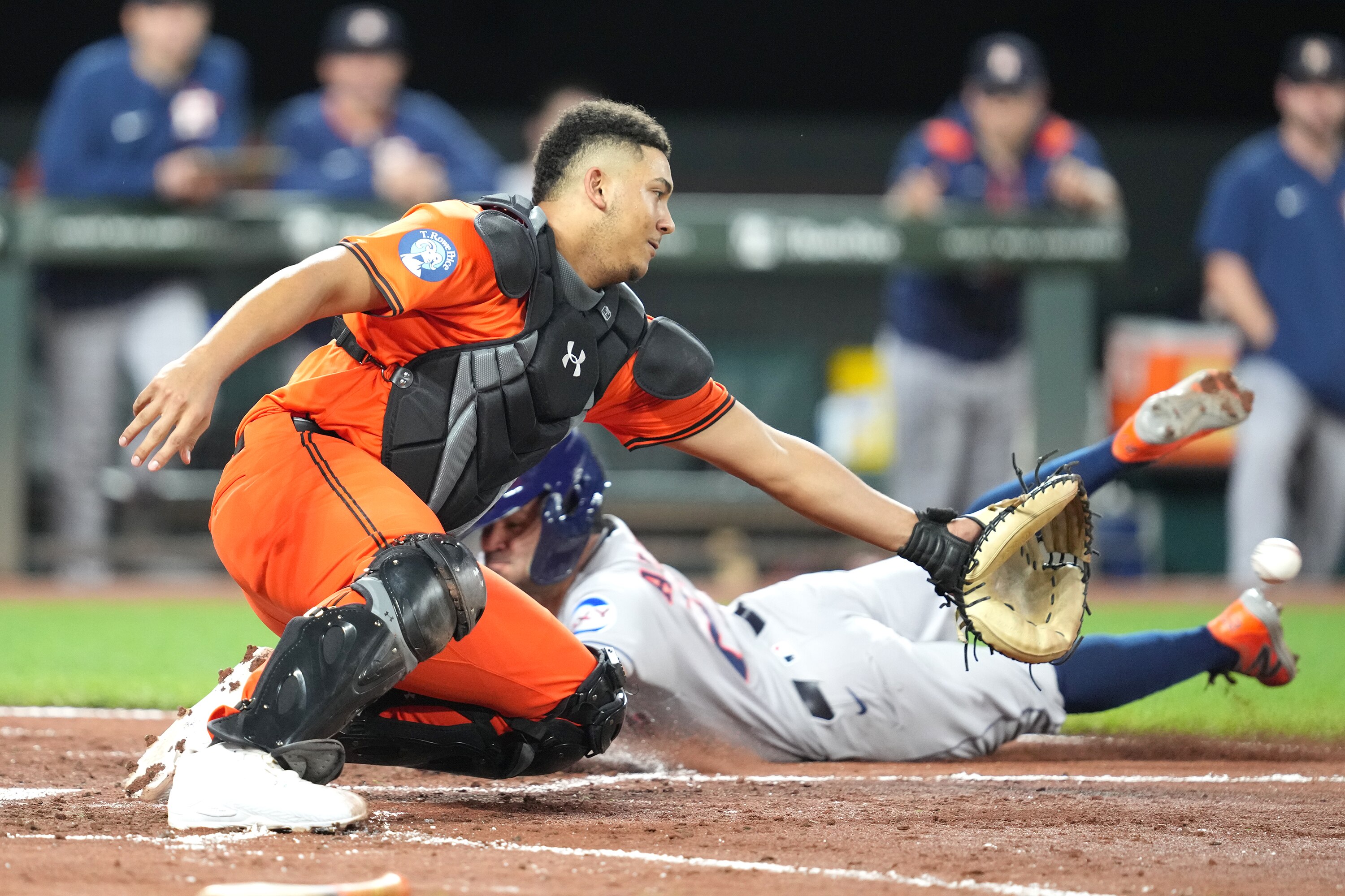 Jose Altuve of the Astros scores as the throw gets away from Orioles catcher Samuel Basallo.