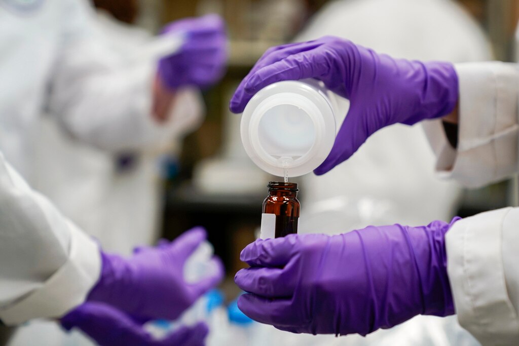 In this file photo, Eva Stebel, a water researcher, pours a water sample into a smaller glass container for experimentation as part of drinking water and PFAS research at the U.S. Environmental Protection Agency Center For Environmental Solutions and Emergency Response.