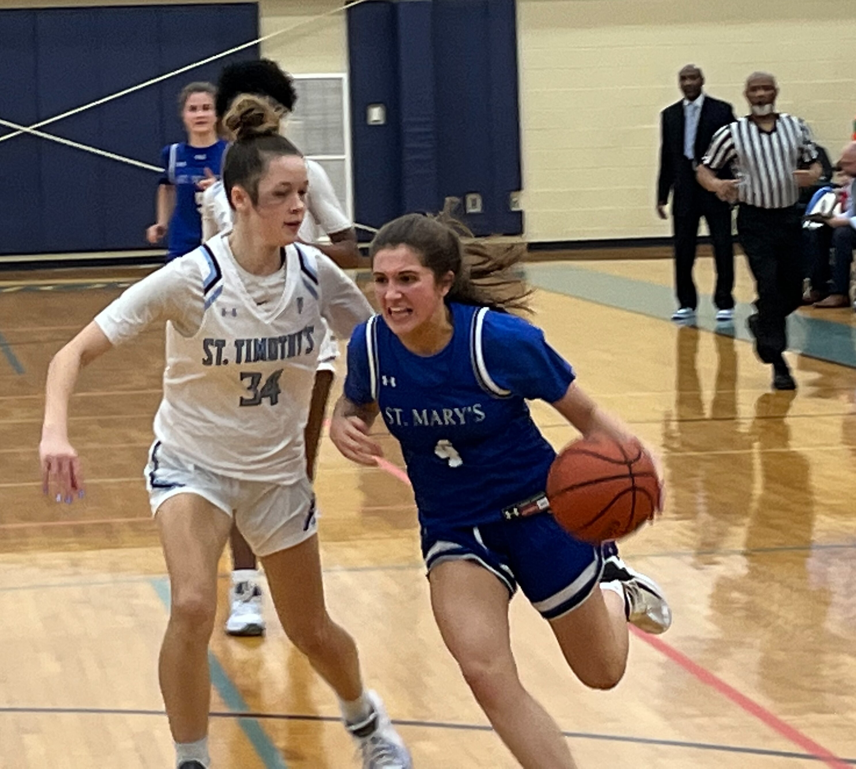 St. Mary's guard Baily Walden (4) drives past St. Timothy's Kira Upton during Tuesday's key IAAM B Conference basketball match. The No. 12 Saints remained undefeated with a 62-52 decision in Baltimore County.