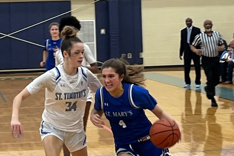 St. Mary's guard Baily Walden (4) drives past St. Timothy's Kira Upton during Tuesday's key IAAM B Conference basketball match. The No. 12 Saints remained undefeated with a 62-52 decision in Baltimore County.