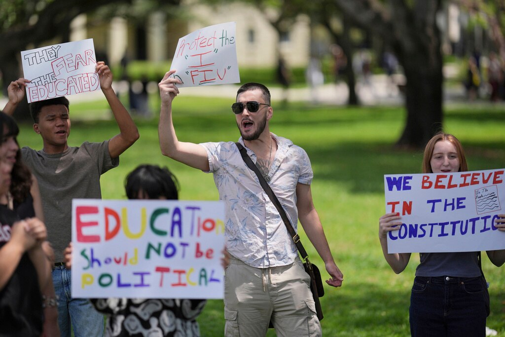 A group of Florida International University students protest against cuts in federal funding and an agreement by campus police to partner with ICE
