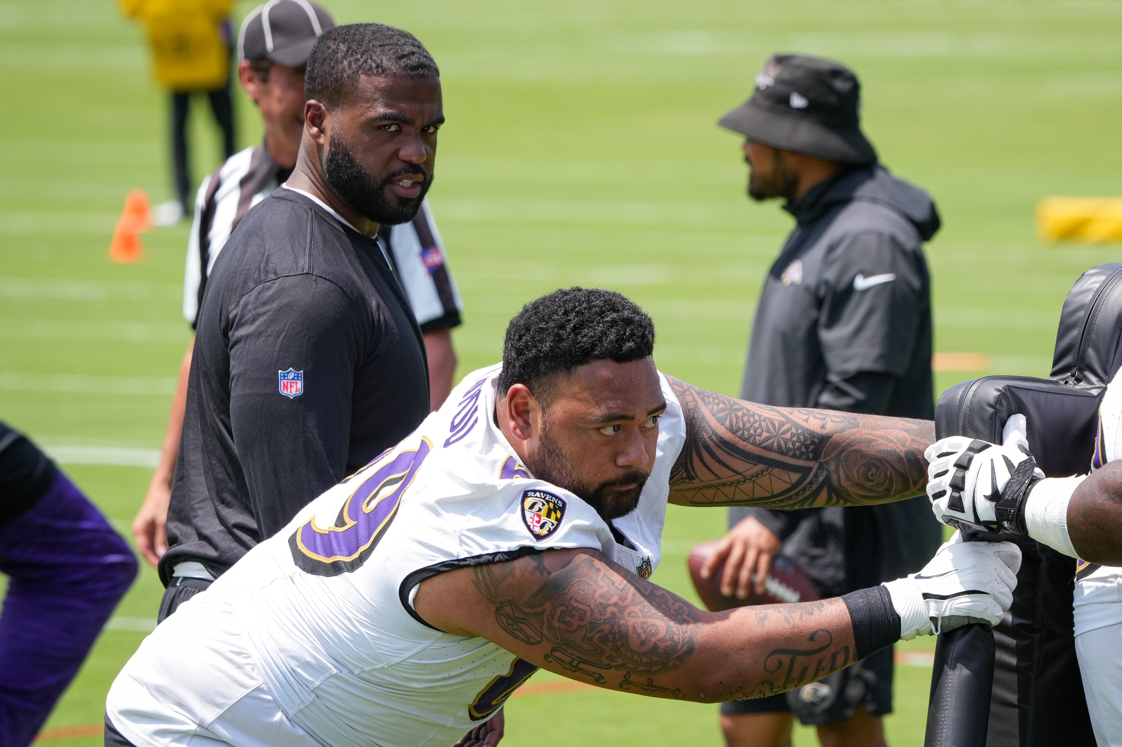 Ravens defensive line coach Dennis Johnson watches tackle Josh Tupou during organized team activities Tuesday.