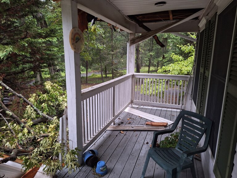 A large tree crashed onto the front of a home in Pasadena during severe thunderstorms Saturday, July 18, 2026, damaging the roof and blocking the front entrance.