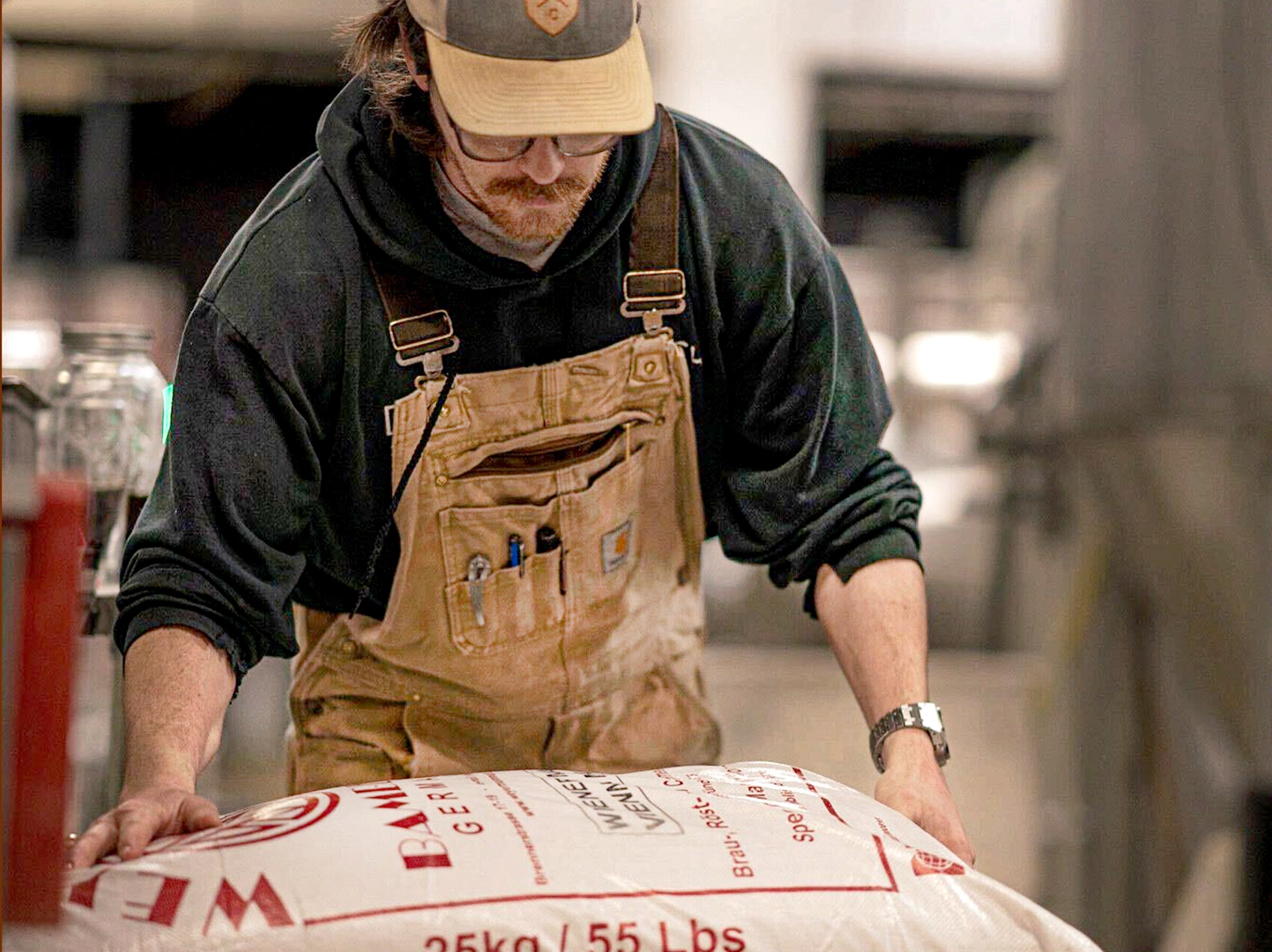 Brewer David Hooper is stacking bags of grain in preparation for mill and mash at the Diamondback Brewing Company in Baltimore, MD.