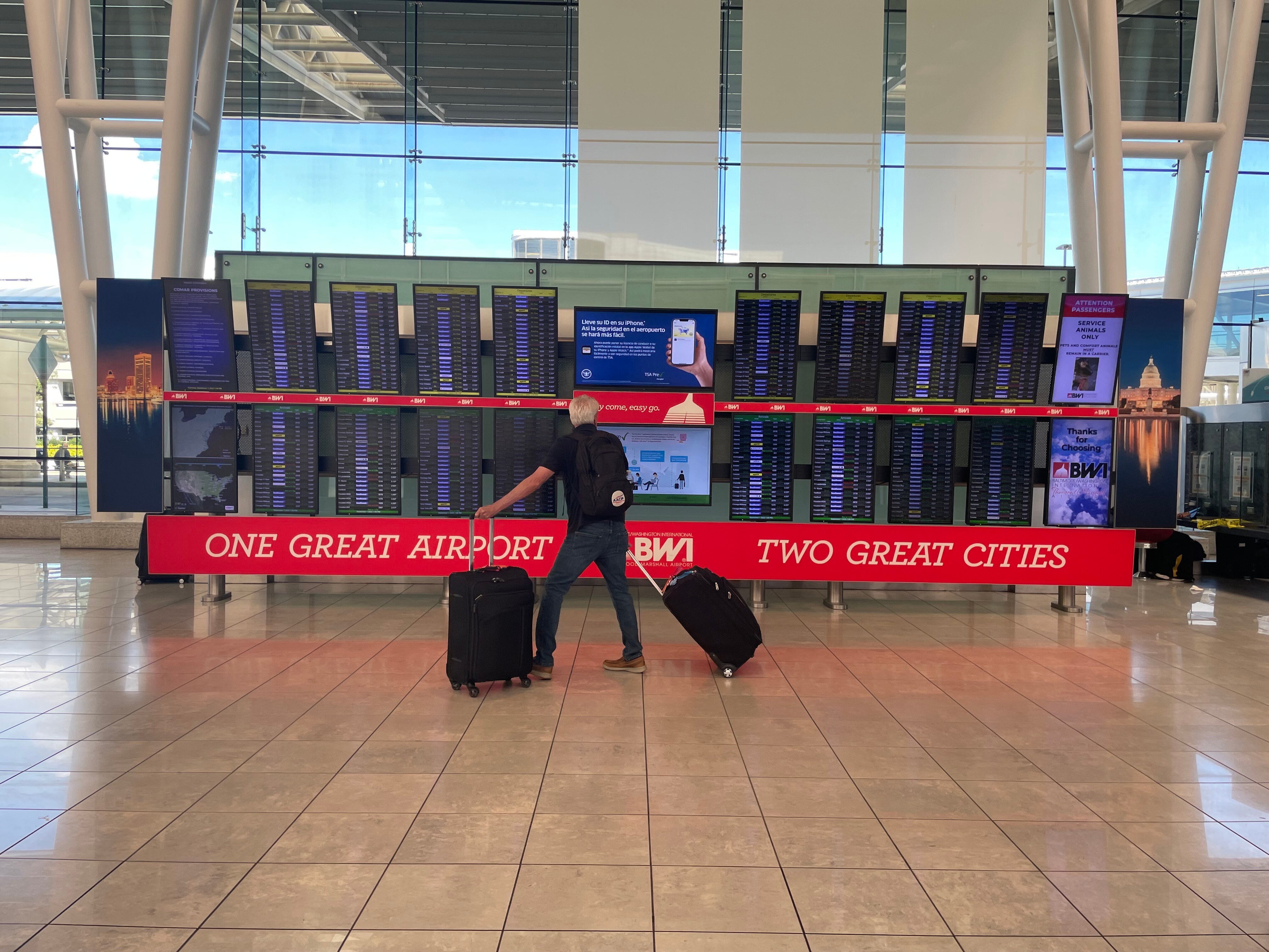 A traveler stands to view arrival and departure information at Baltimore-Washington Thurgood International Airport.