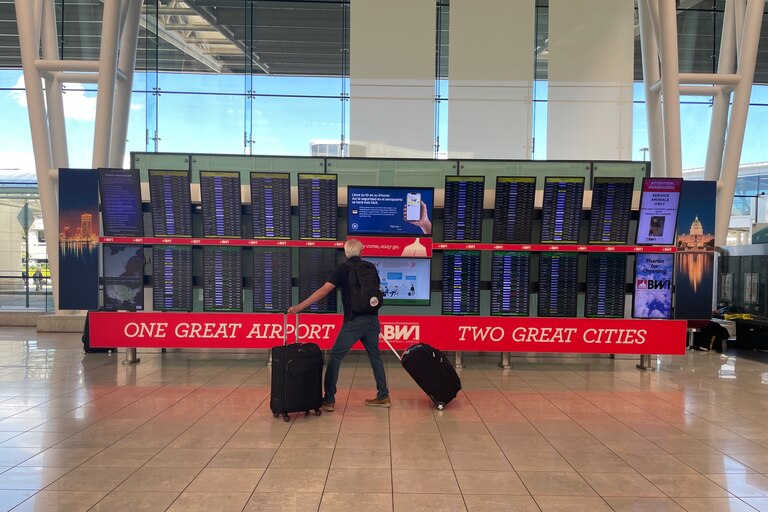 A traveler stands to view arrival and departure information at Baltimore-Washington Thurgood International Airport.