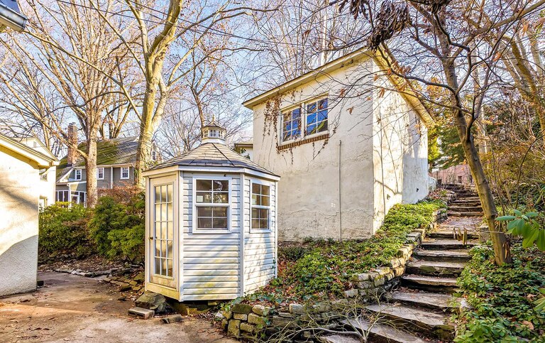 A stone walkway leads to a back patio.