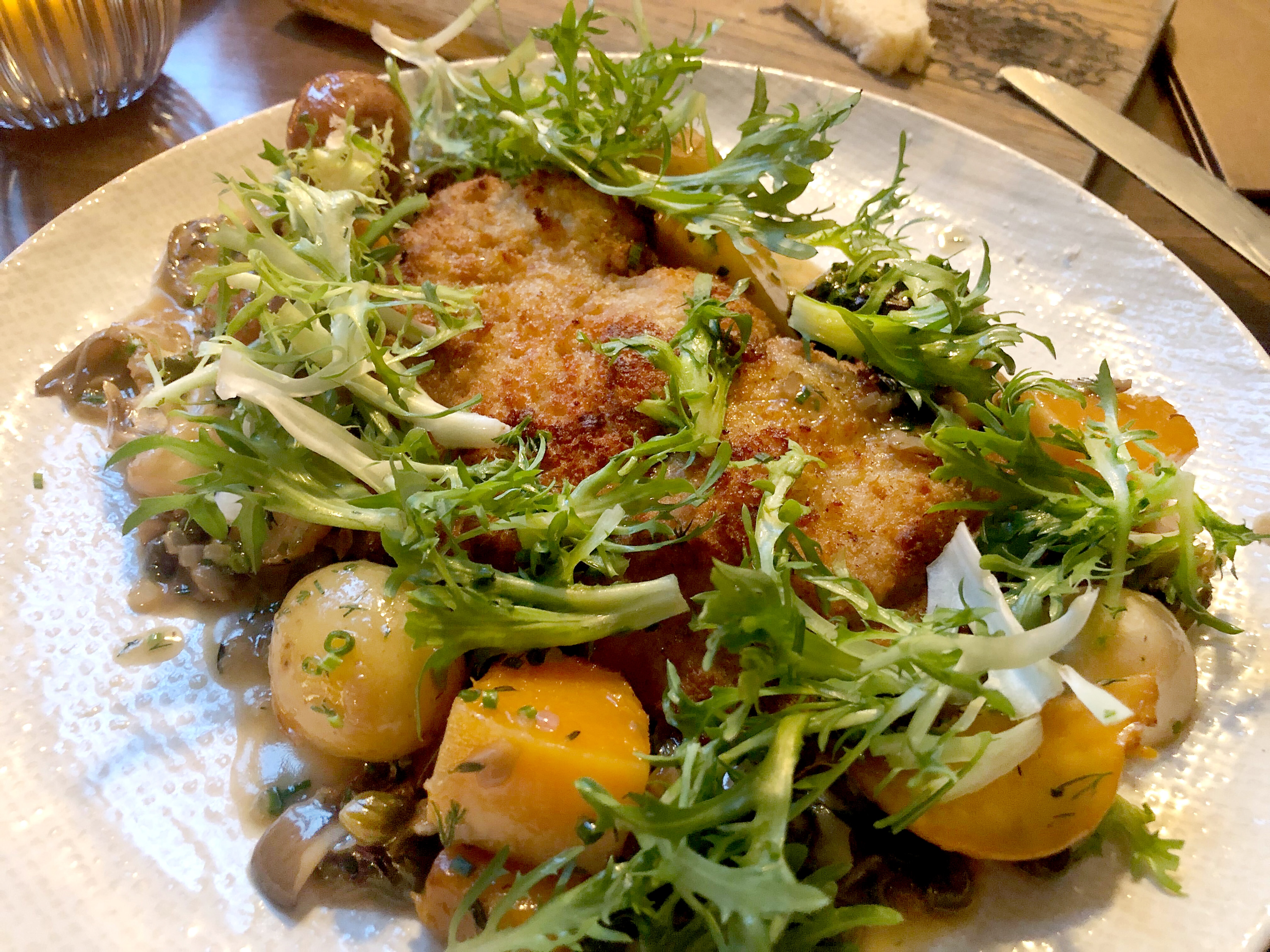 The blue catfish at True Chesapeake Oyster Co. is breaded and comes served with squash, potatoes and salad greens.