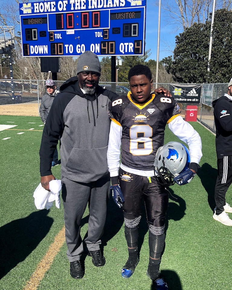 Zion Young, right, with his father Frank Young at a youth football game.