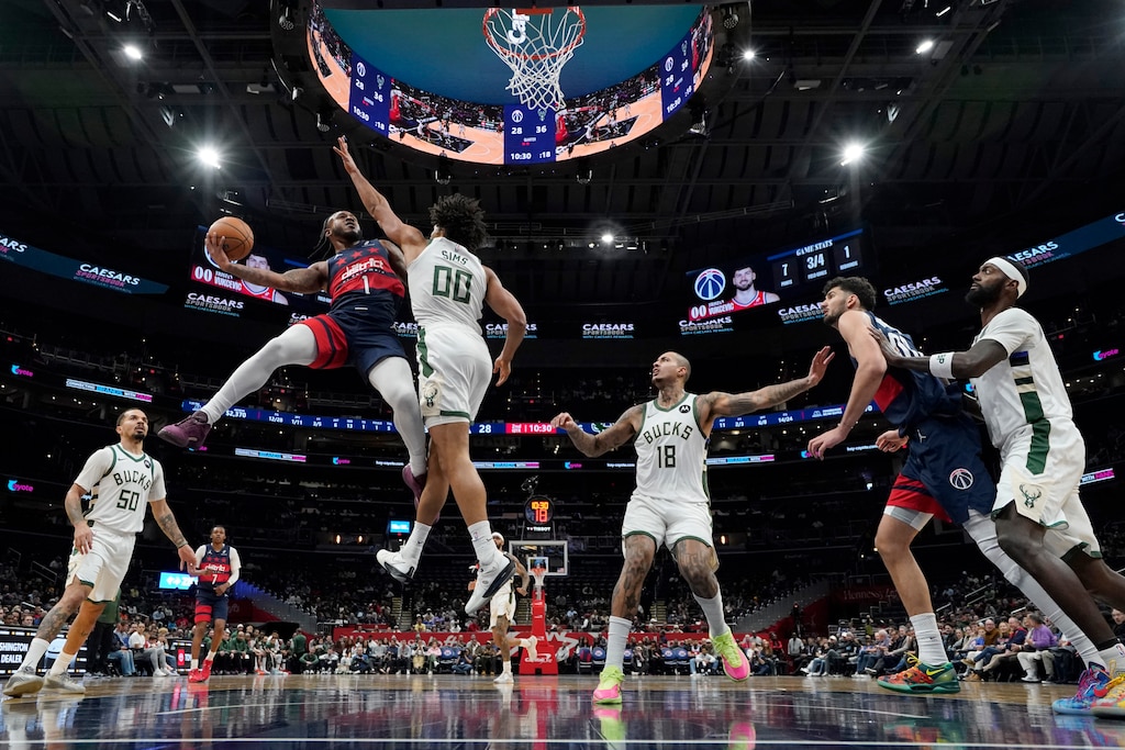 WASHINGTON, DC - DECEMBER 01: Cam Whitmore #1 of the Washington Wizards goes up against Jericho Sims #00 of the Milwaukee Bucks during the first half at Capital One Arena on December 01, 2025 in Washington, D.C.