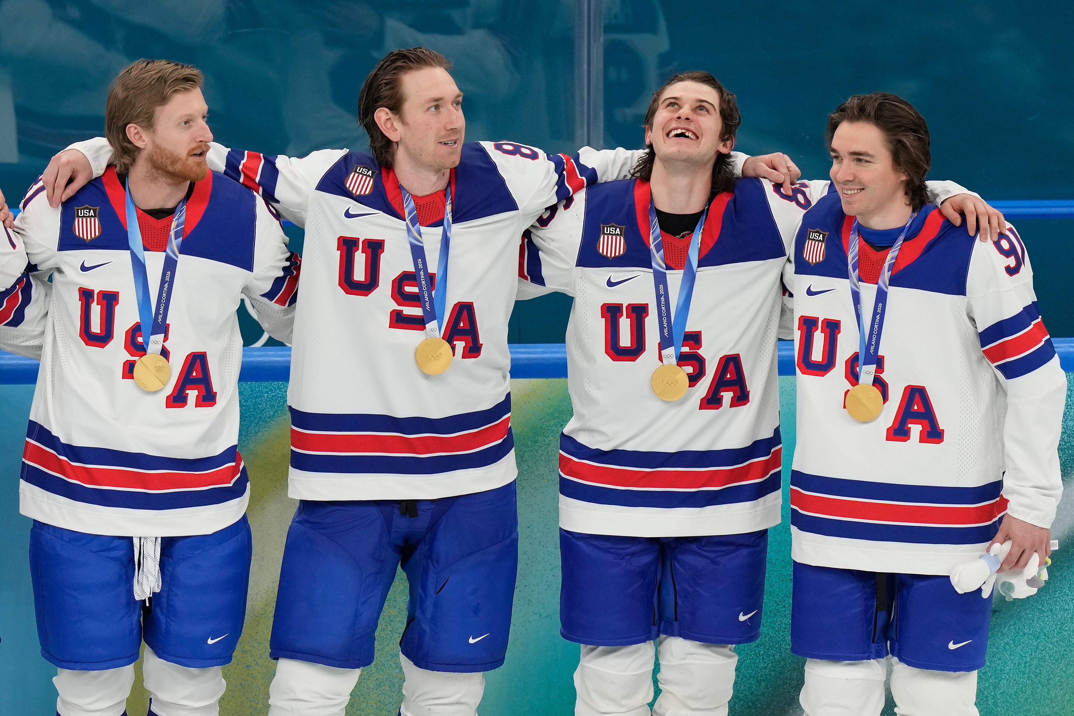 United States' Kyle Connor (81), Zach Werenski (8), Jack Hughes (86) and Clayton Keller (91) react after receiving their gold medals after the United States defeated Canada in the men's ice hockey gold medal game at the 2026 Winter Olympics, in Milan, Italy, Sunday, Feb. 22, 2026.