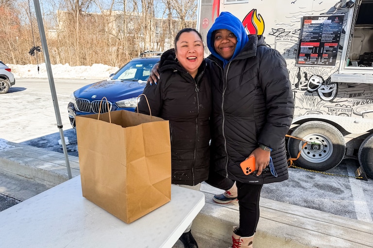 Owner of Namit BBQ Food Truck Maria Tabligan poses with customer Valerie Forrester, who's stocking up on meat skewers as the truck closes until Spring.