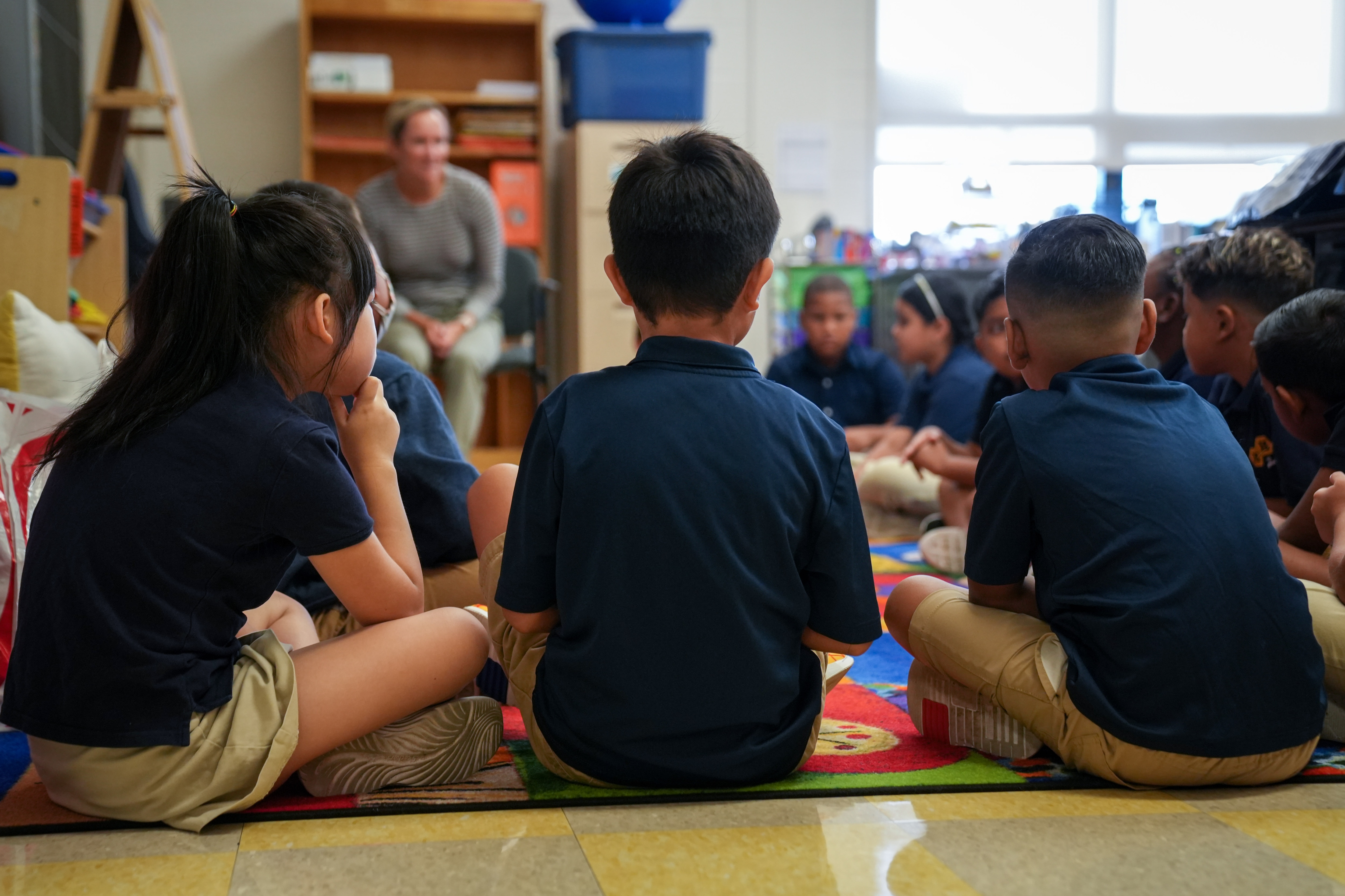 Students sit together on a rug inside their Hampstead Hill Academy classroom on 8/29/22. Monday was the first day back to school for Baltimore City students.