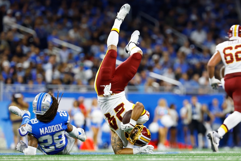Washington Commanders running back Craig Reynolds (24) is flipped by Detroit Lions cornerback Avonte Maddox (29) during a preseason NFL football game, Saturday, Aug. 22, 2026, in Detroit. (AP Photo/Rey Del Rio)