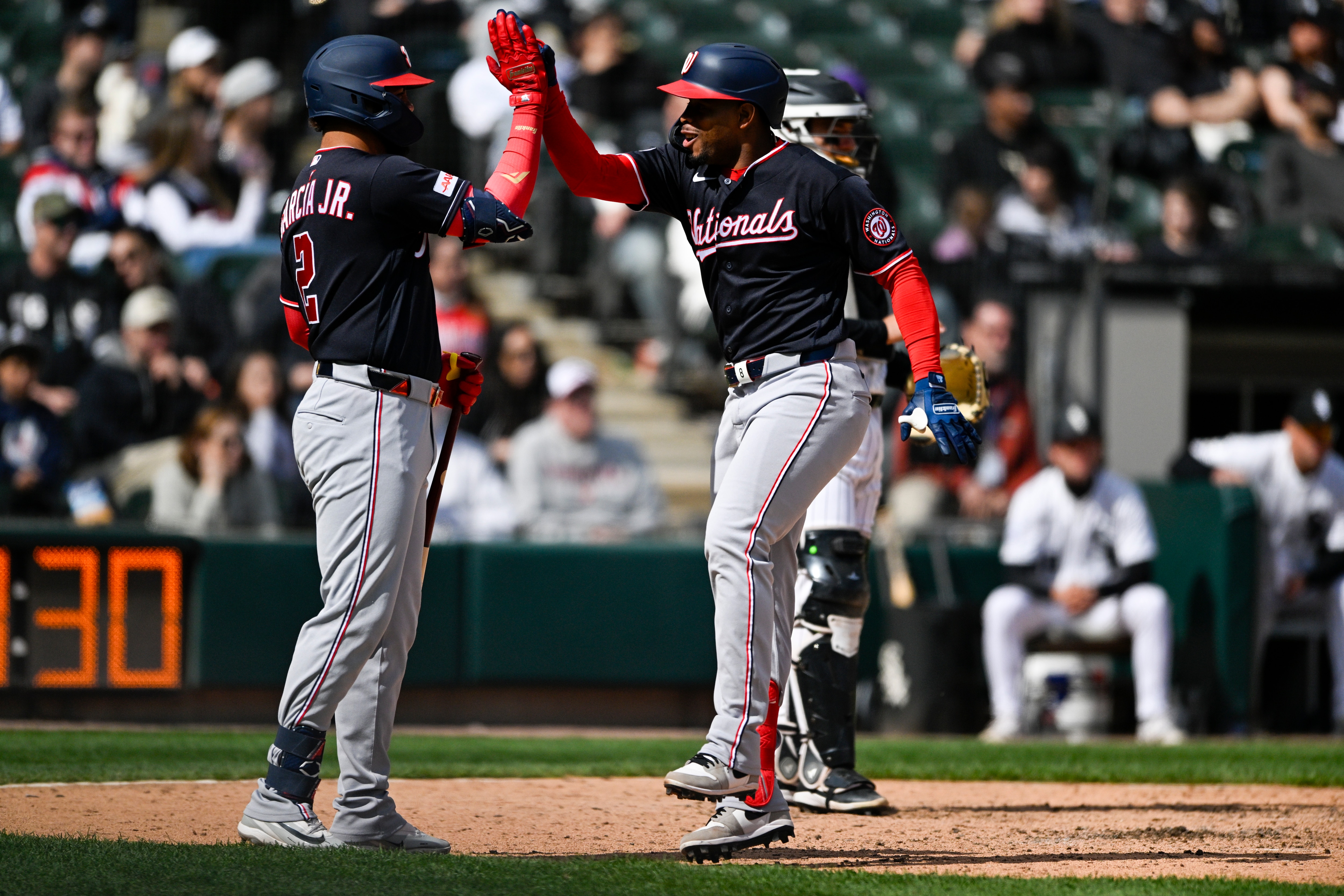 José Tena high-fives Luis García Jr. after Tena's solo home run in the 10th inning of the Nationals’ 2-1 win over the White Sox on Sunday.