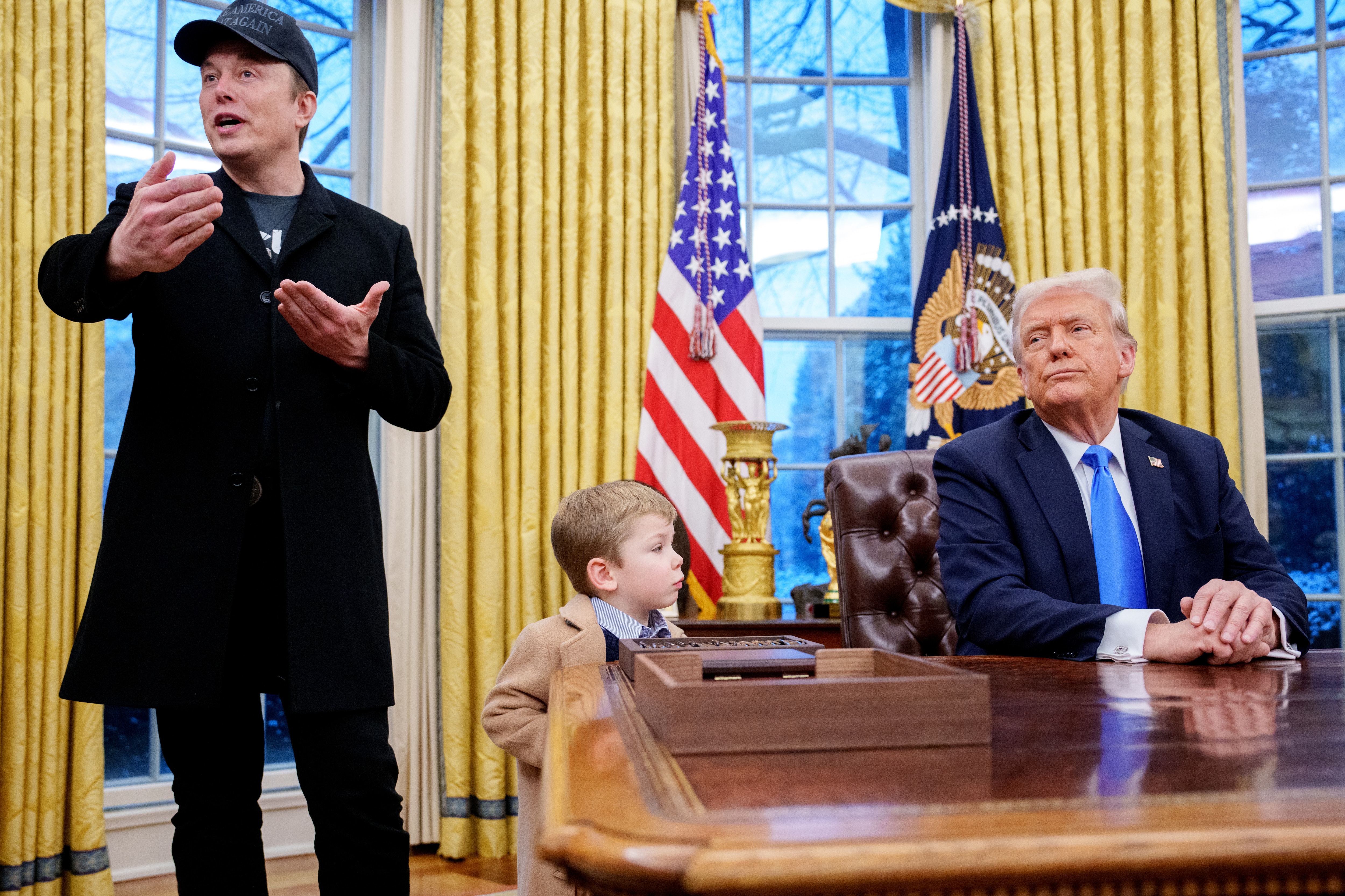 Elon Musk, accompanied by U.S. President Donald Trump, and his son X Musk, speaks during an executive order signing in the Oval Office at the White House on February 11, 2025 in Washington, DC.