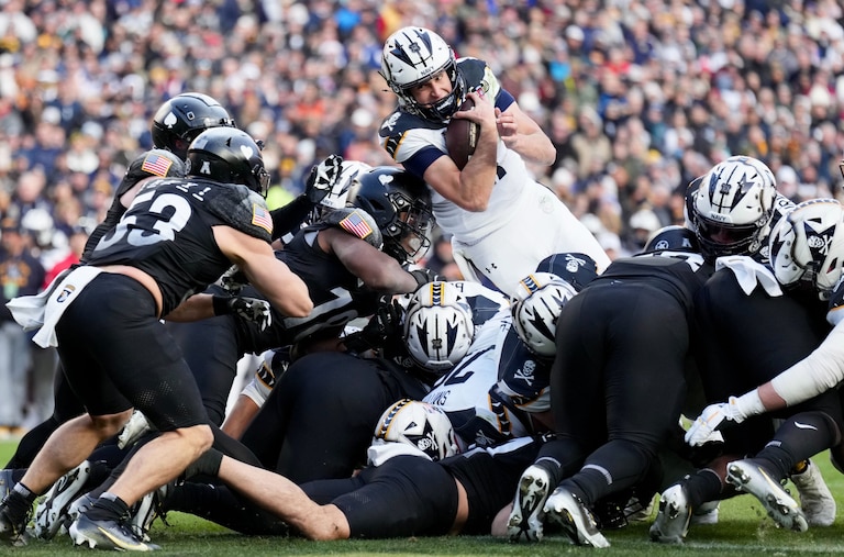 Navy quarterback Blake Horvath jumps over the middle to score a touchdown in the first quarter of the 125th Army-Navy football game at Northwest Stadium on December 14, 2024 in Landover, Maryland.