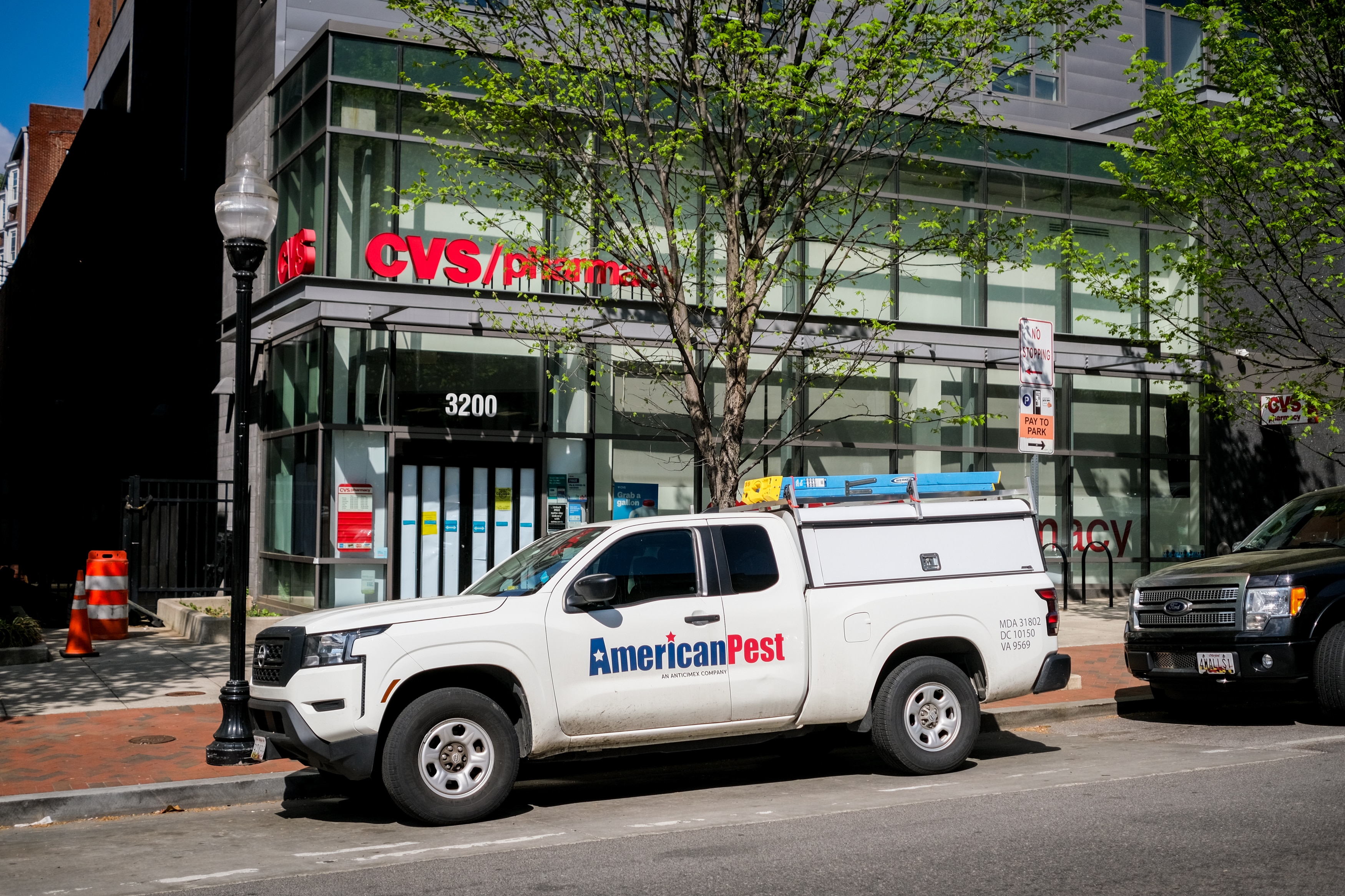 A pest control vehicle is parked outside the temporarily closed CVS at 3200 Saint Paul St. on Friday. Paper blocks the windows and a sign on the door indicates a rodent infestation.