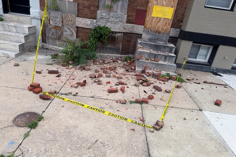 Bricks that fell off the longest-vacant home in the city on May 20, 2026 lay scattered on the sidewalk.