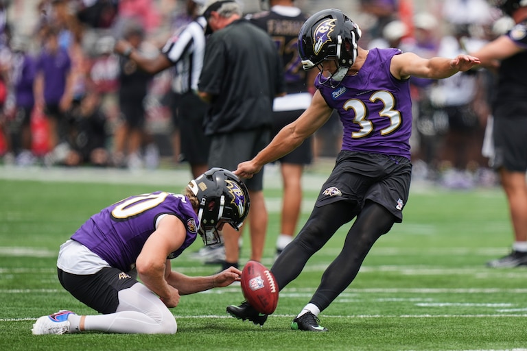 Baltimore Ravens place kicker Tyler Loop (33), with punter Ryan Eckley holding, works out during the team's NFL football training camp, Saturday, Aug. 1, 2026, at the University of Maryland in College Park, Md. (AP Photo/Stephanie Scarbrough)