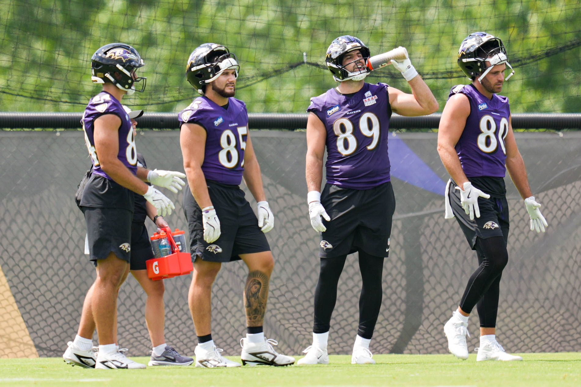 Ravens tight ends Ty Pezza, (84), Josh Cuevas (85) Mark Andrews (89) and Durham Smythe (80) take a break after completing drills during practice on July 29.