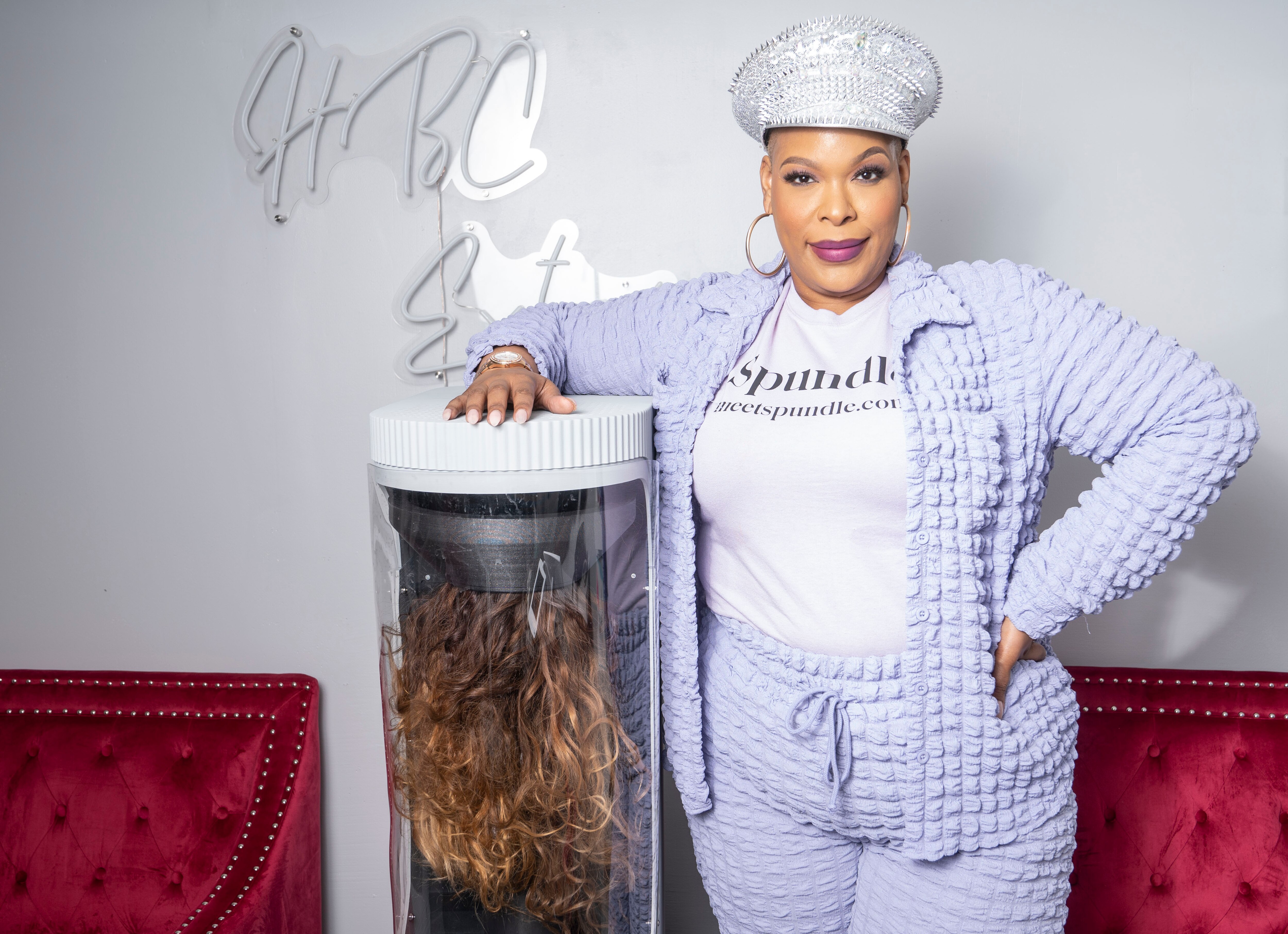 Shawna Stepp-Jones poses for a portrait next to her creation, the Spundle, a fast, no-heat hair dryer for wigs and extensions, in Baltimore, Tuesday, March 28, 2023.