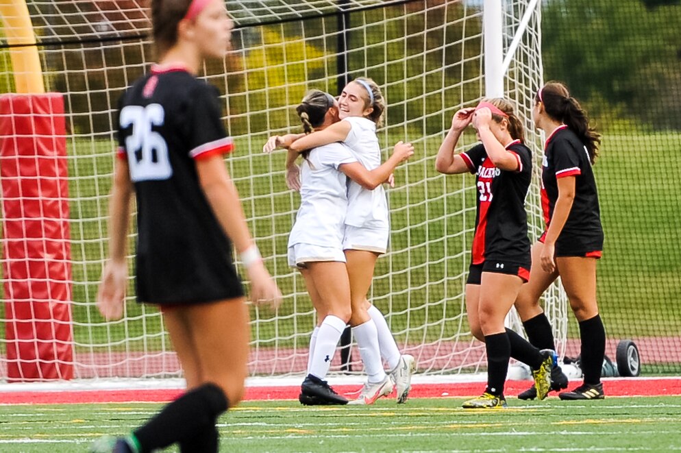 John Carroll’s Ella Steck is embraced by teammate Megann Kalthof after Steck’s goal in the closing minutes of Wednesday's IAAM A Conference soccer game. Steck's tally lifted the No. 8 Patriots to a 2-1 win over top-ranked Spalding.