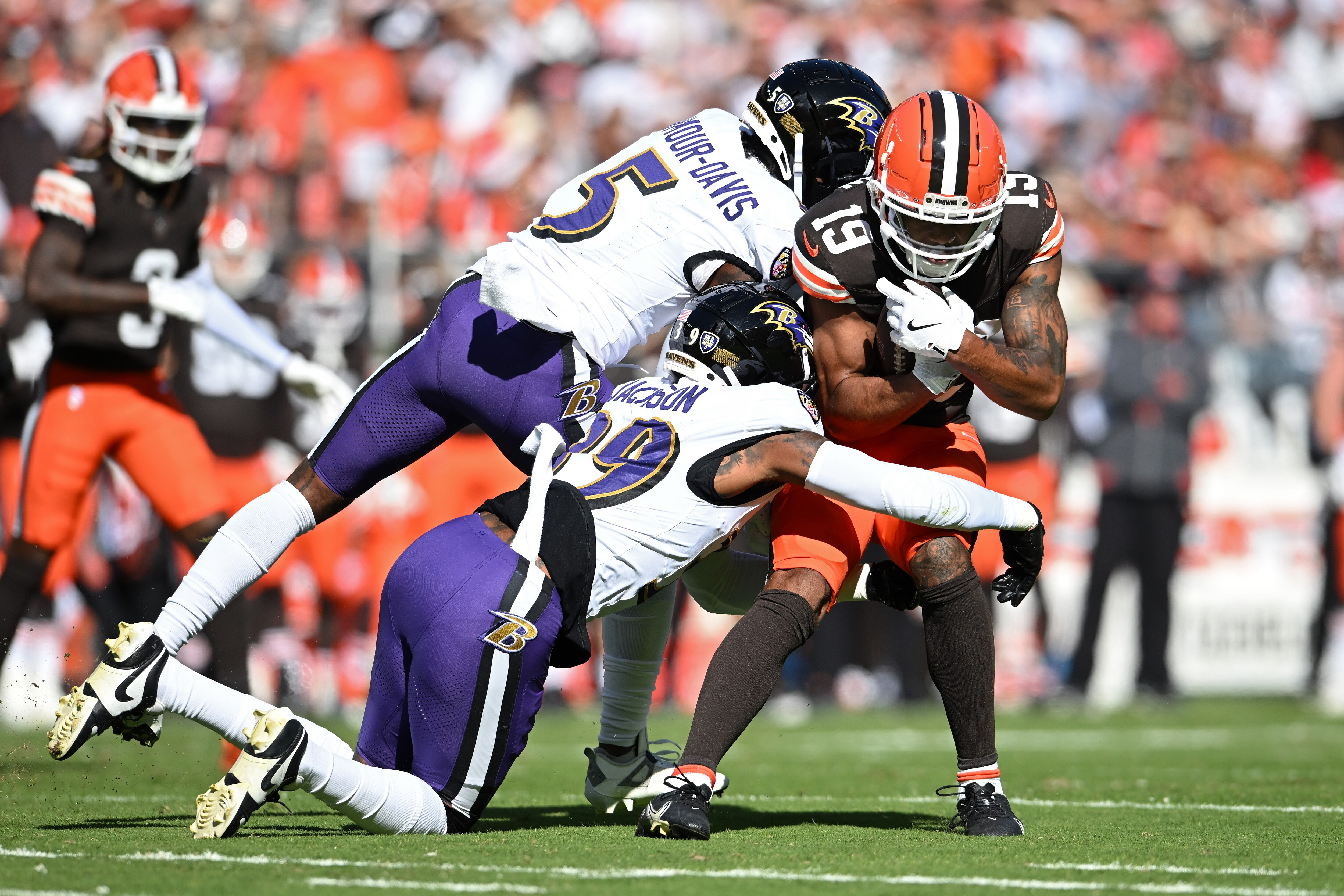 The Ravens’ Jalyn Armour-Davis and Eddie Jackson tackle Cedric Tillman of the Browns during the first half Sunday.