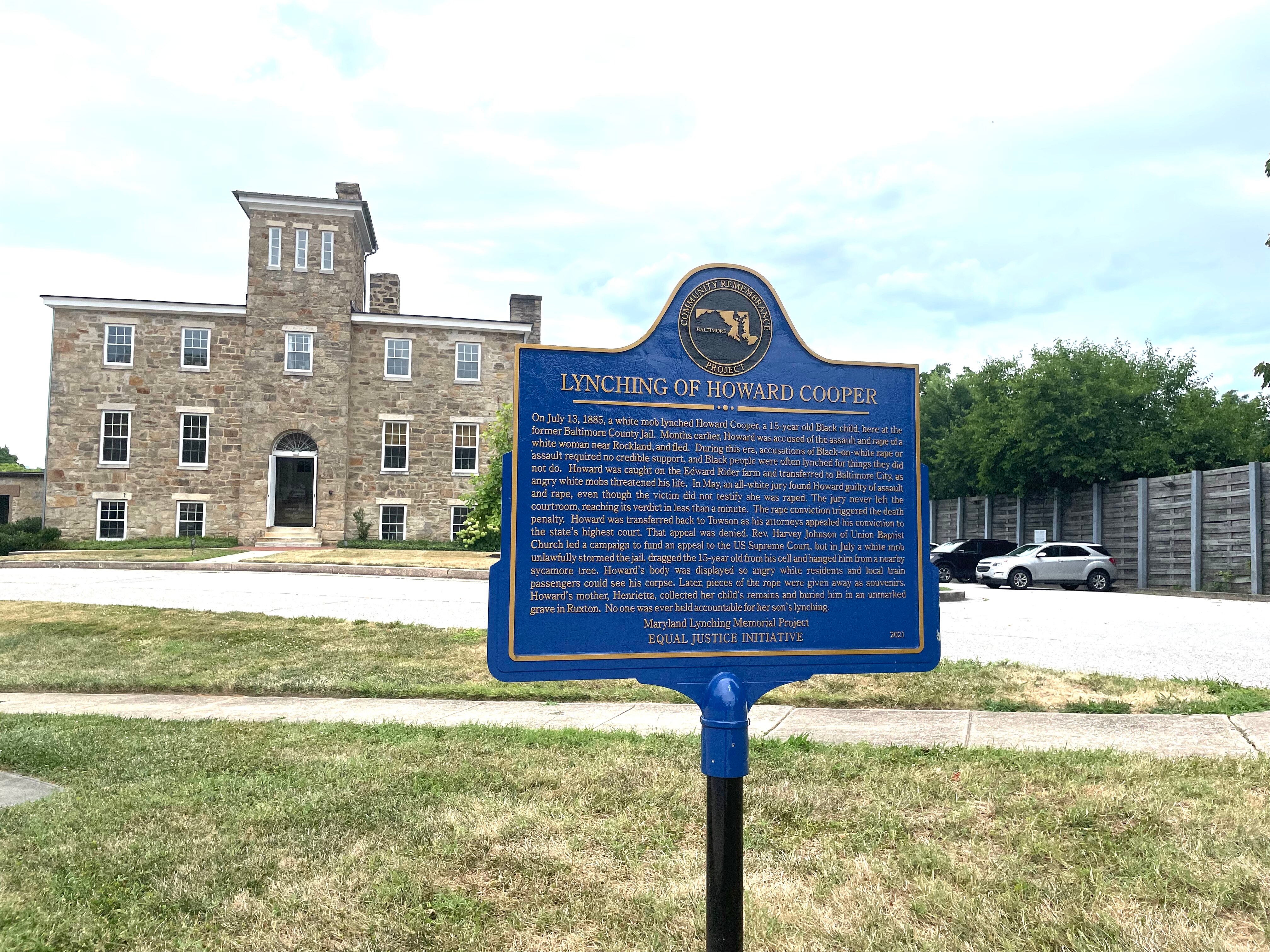 The sign remembering Howard Cooper sits in front of the old Towson jail. A white mob lynched the Black teenager in 1885.